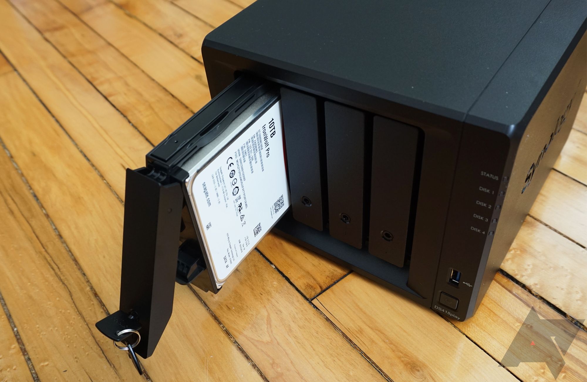 Image shows a NAS enclosure with one of its hard drives unlocked and sliding out.