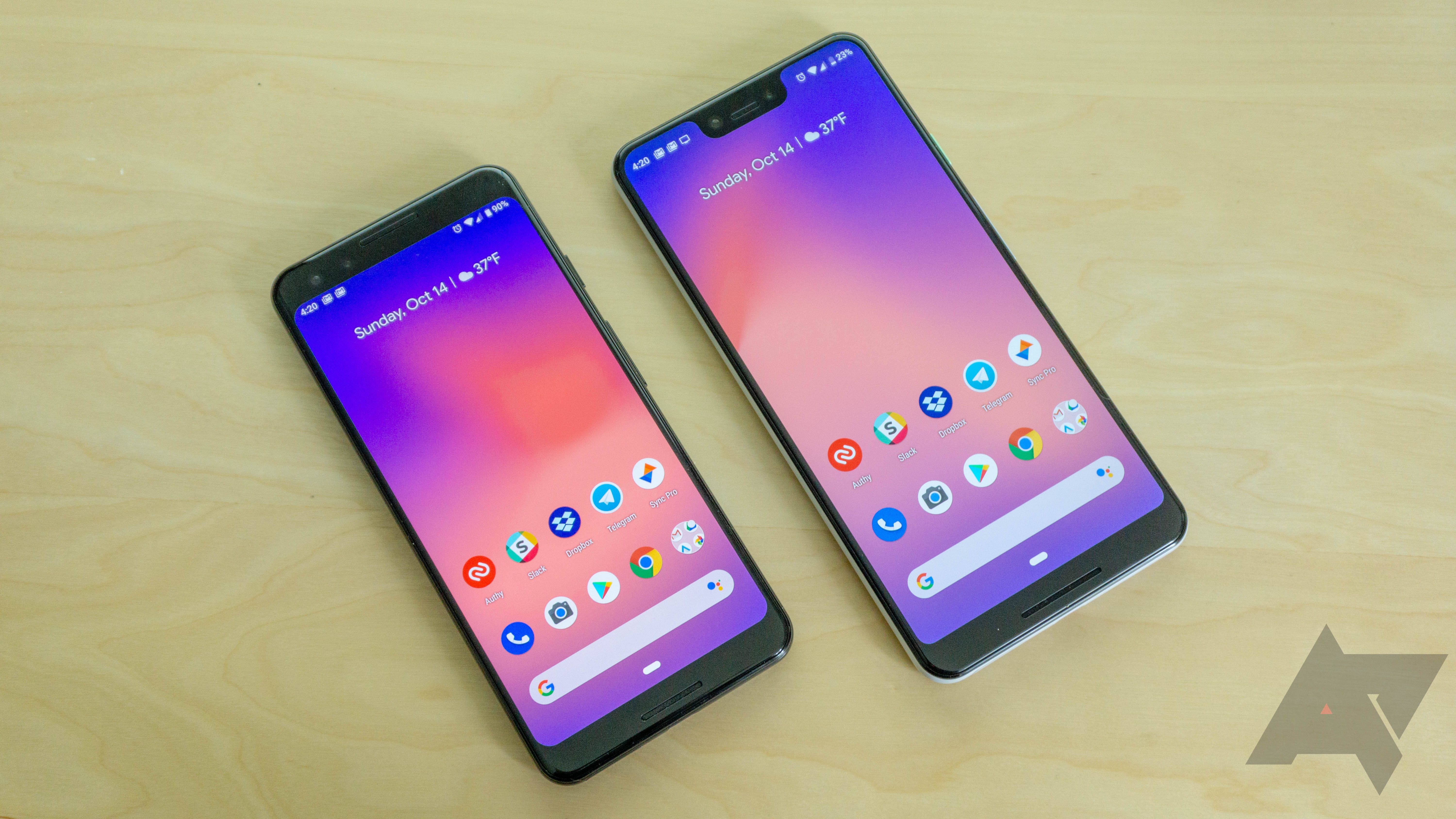 A Google Pixel 3 and 3 XL on a light wood grained surface