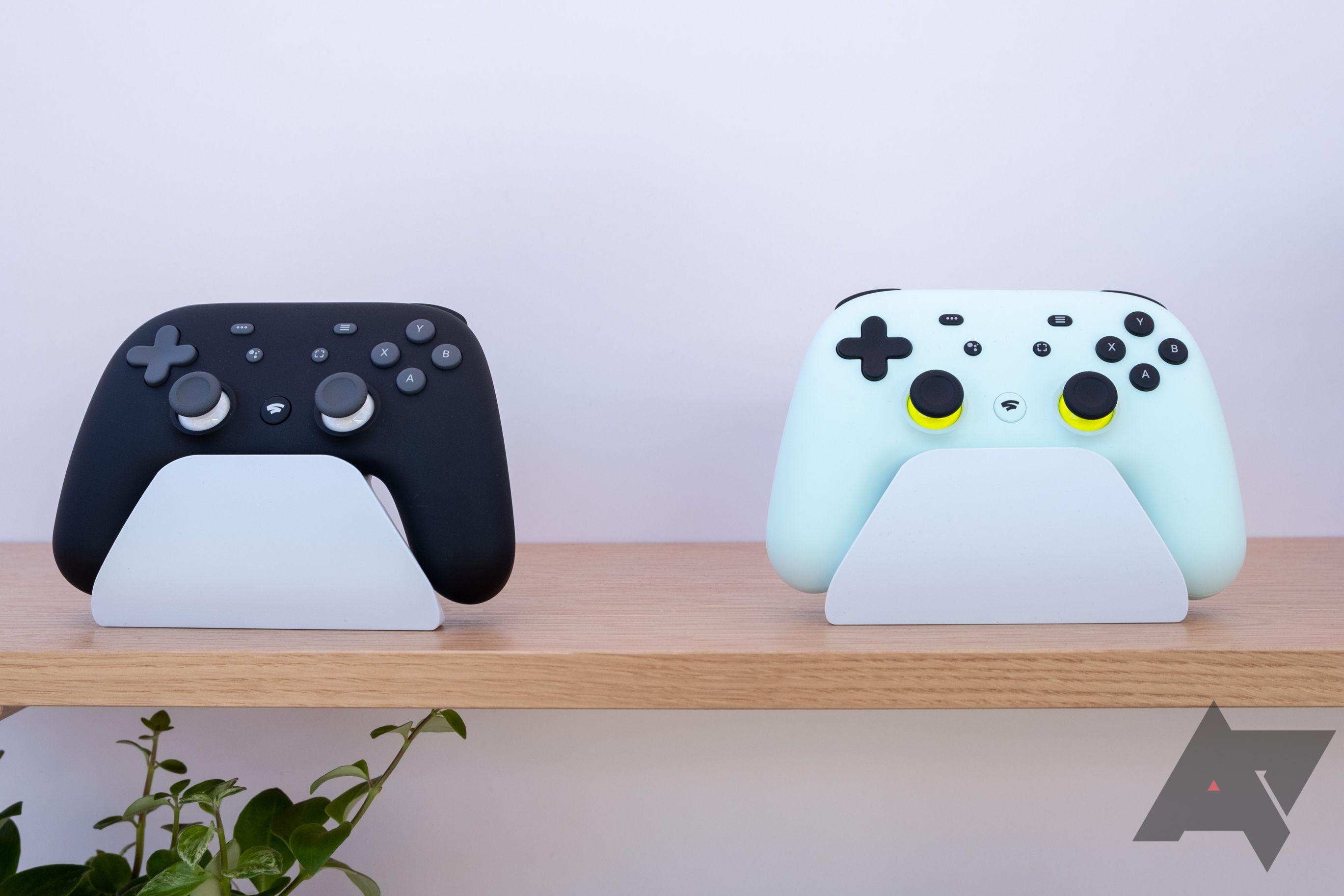 white and black stadia controllers on wood shelf