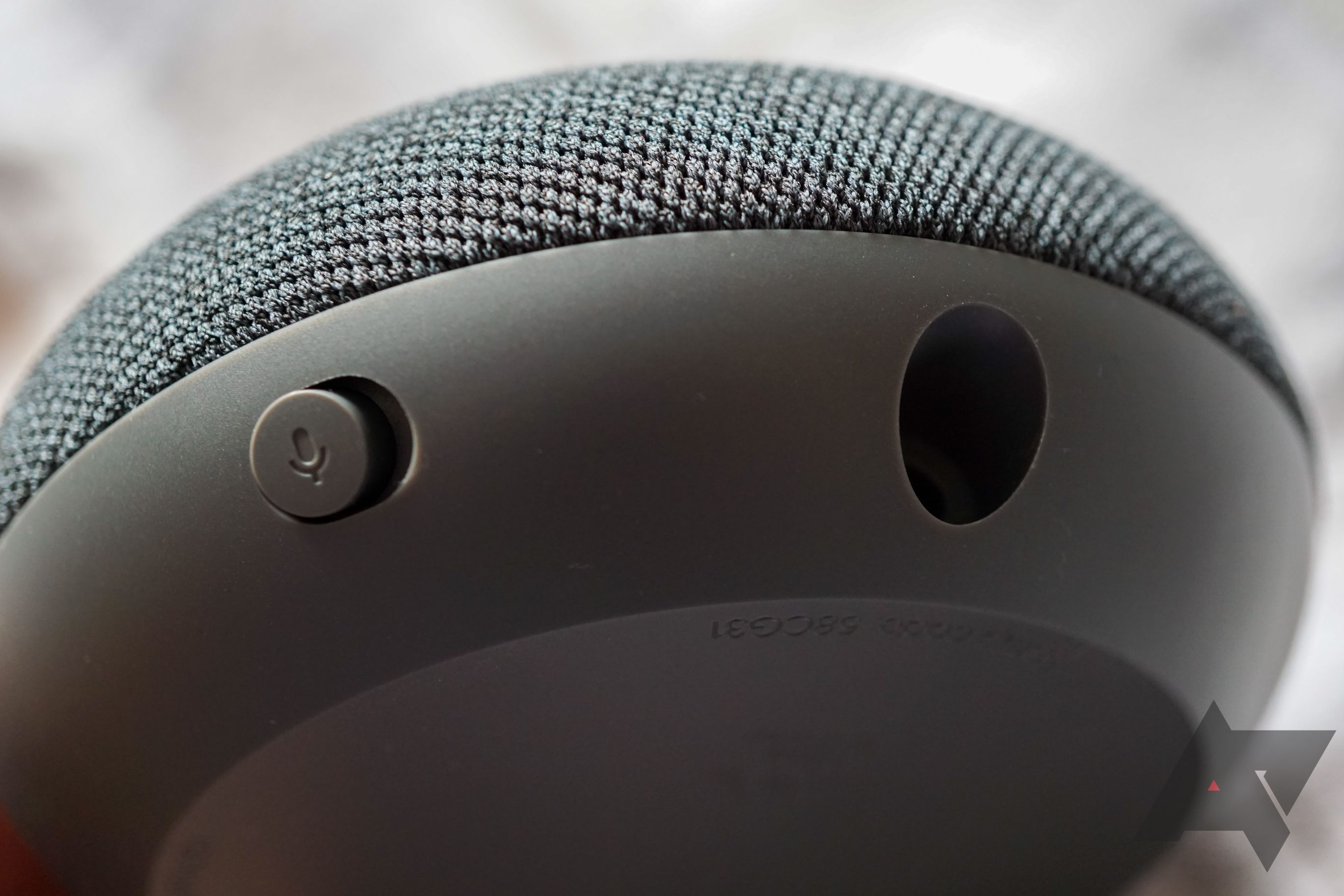 Close-up showing the mute switch and power port of the Google Nest Mini speaker
