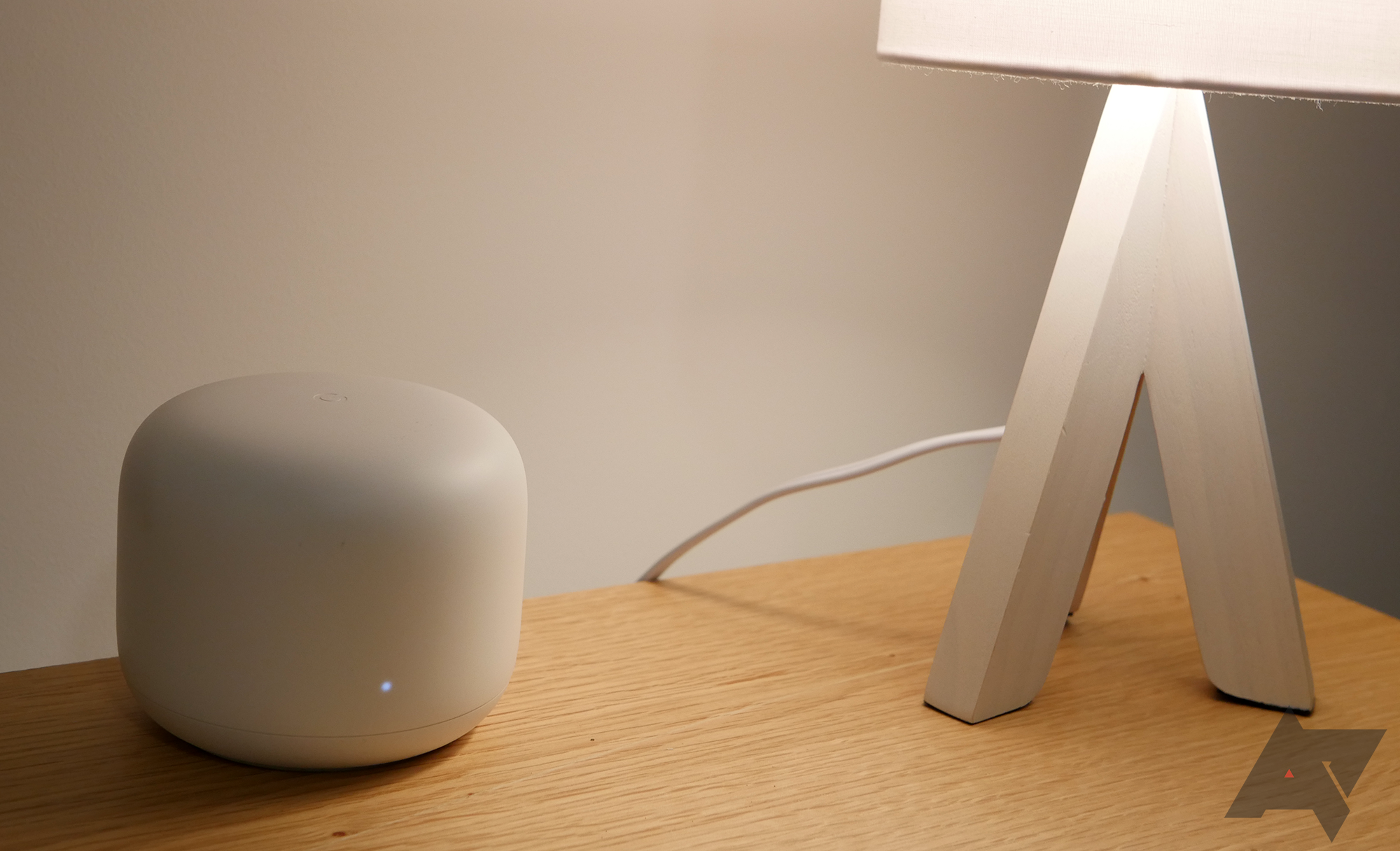 image of a gogle wi-fi router on table next to lamp