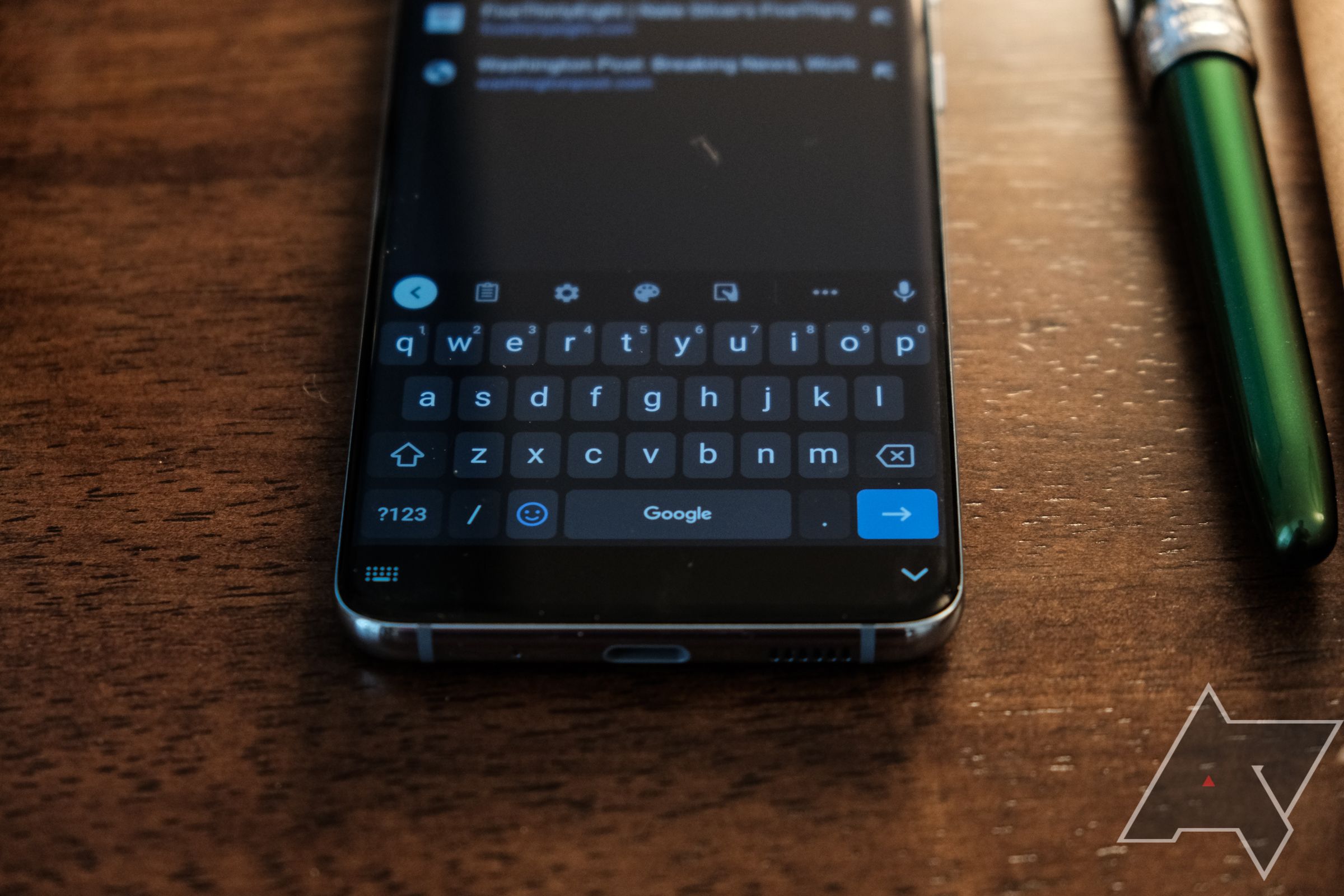 A Samsung Galaxy phone showing the keyboard on the screen.