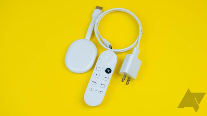 A Google TV Chromecast with its remote, power brick, and cable on a yellow background.