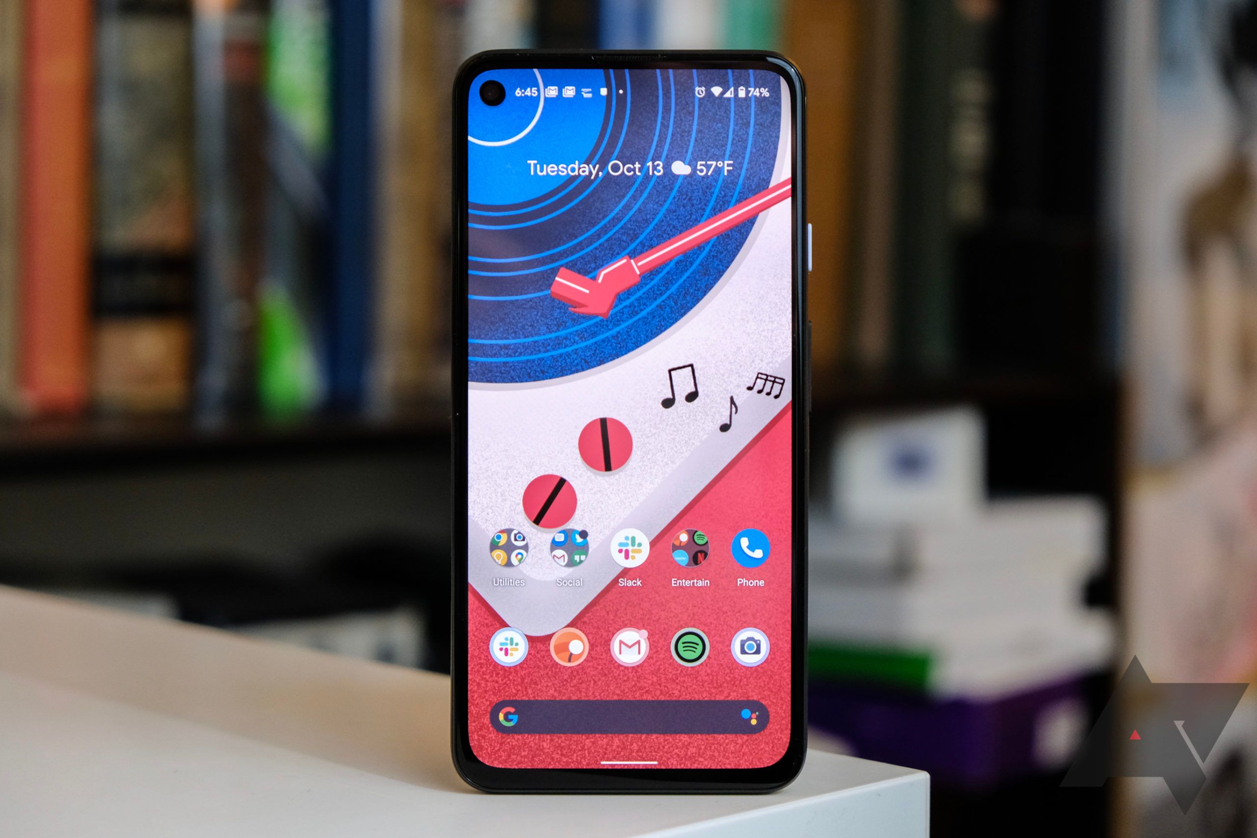 A Google Pixel 4a 5g on a countertop with a bookshelf filled with books in the background