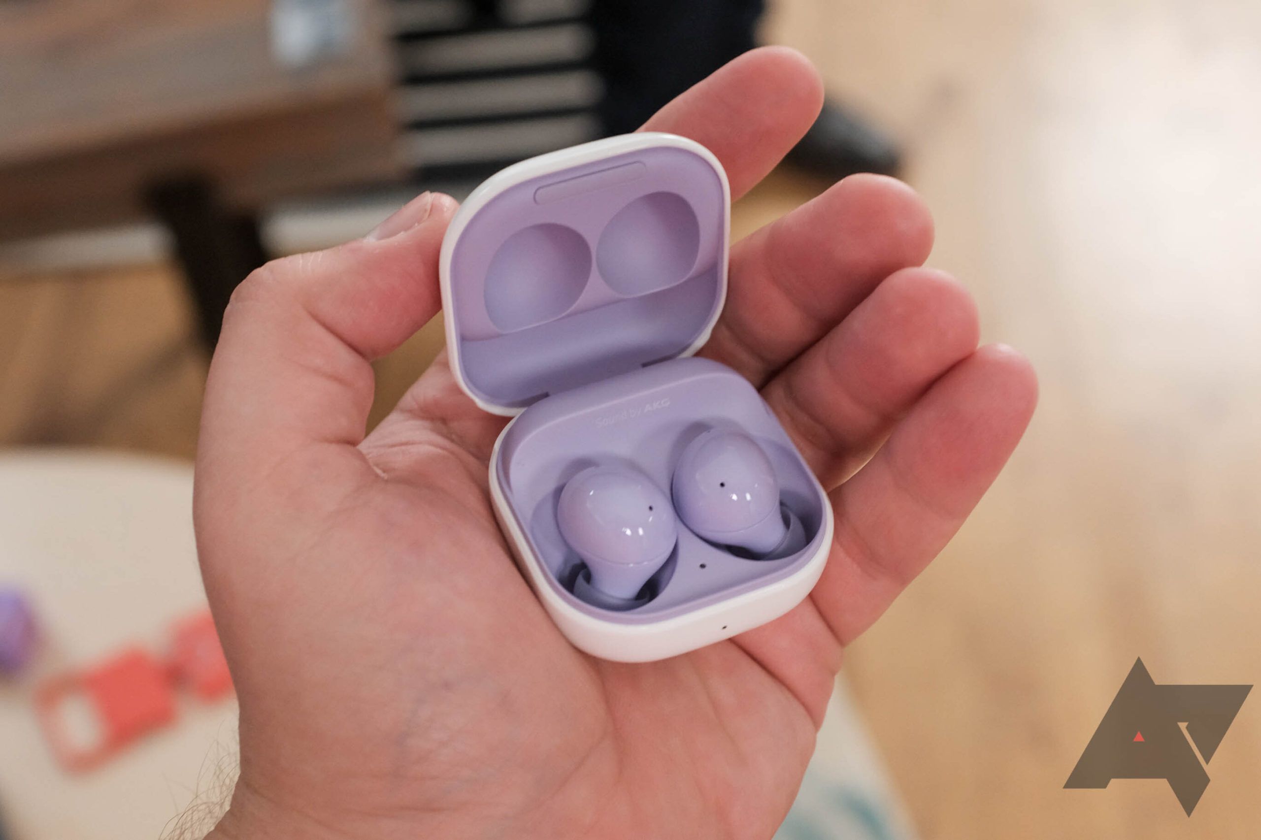 A pair of purple Galaxy Buds in the case