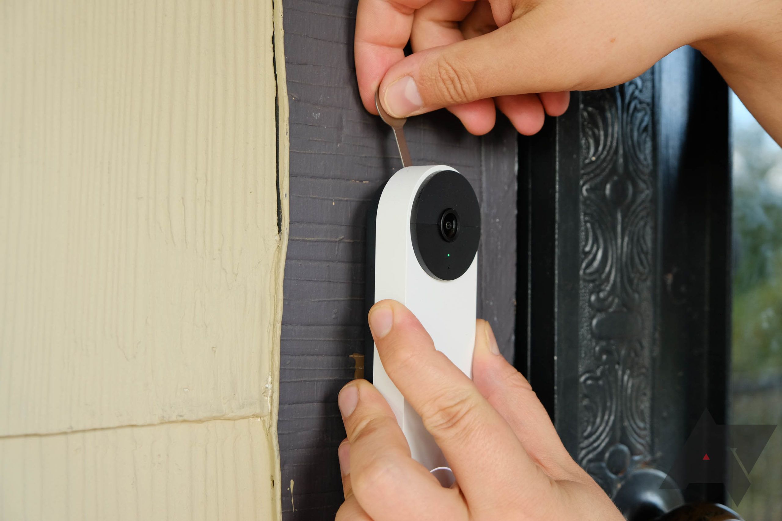 A Nest Video Doorbell being installed.