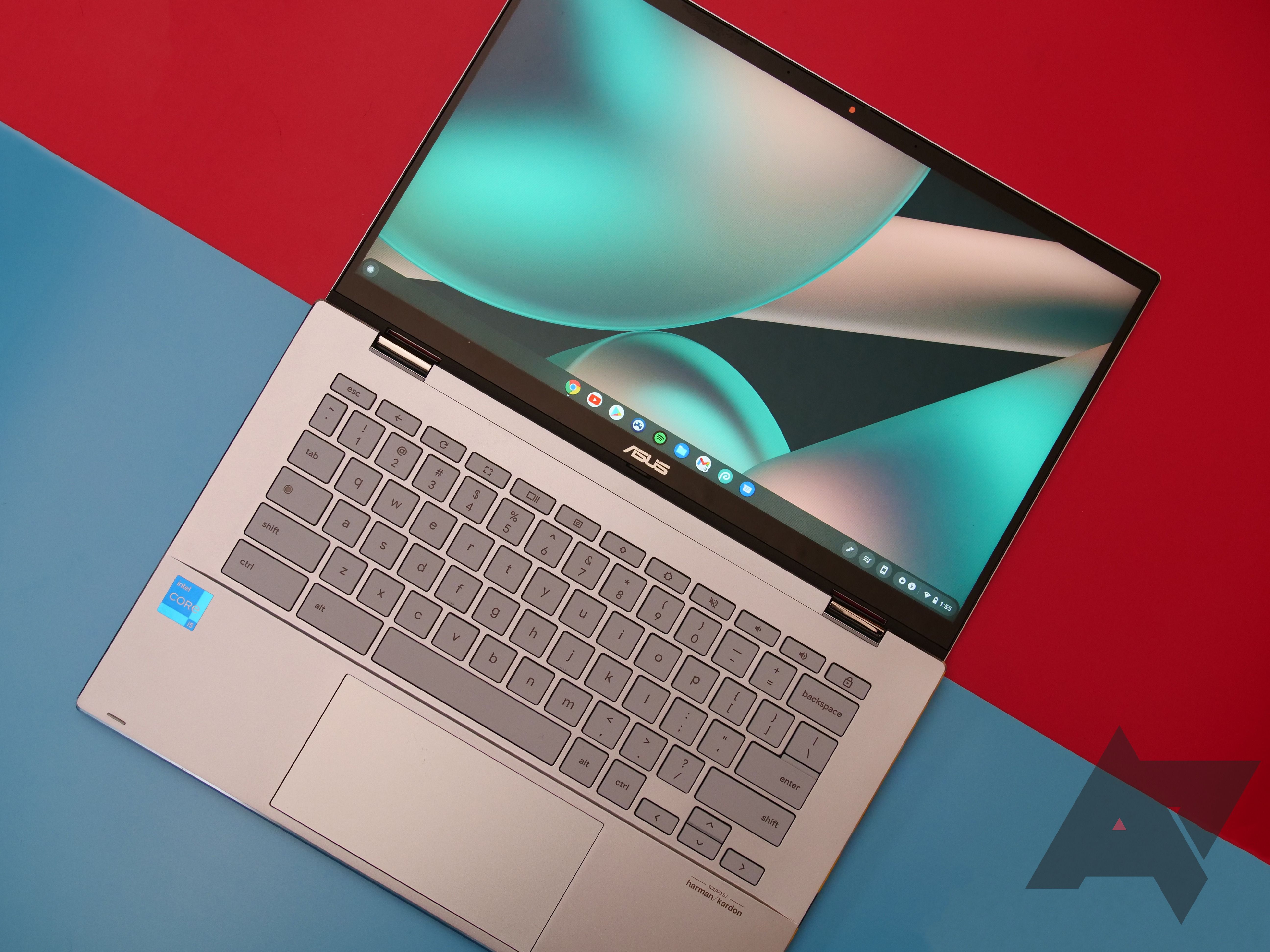 an overhead view of a Chromebook sitting against a red background