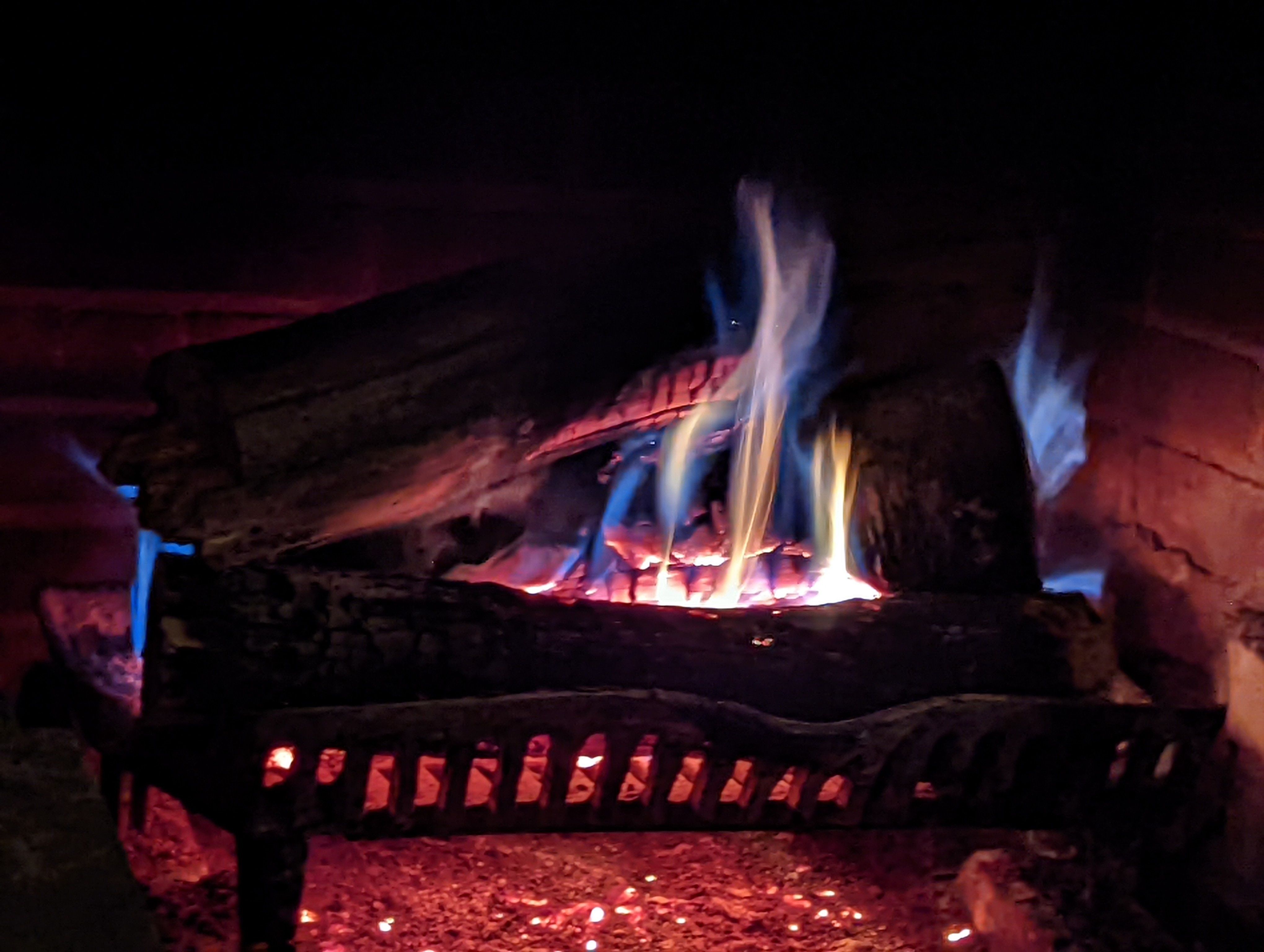 Photo of a fireplace where the logs are obscured in shadow