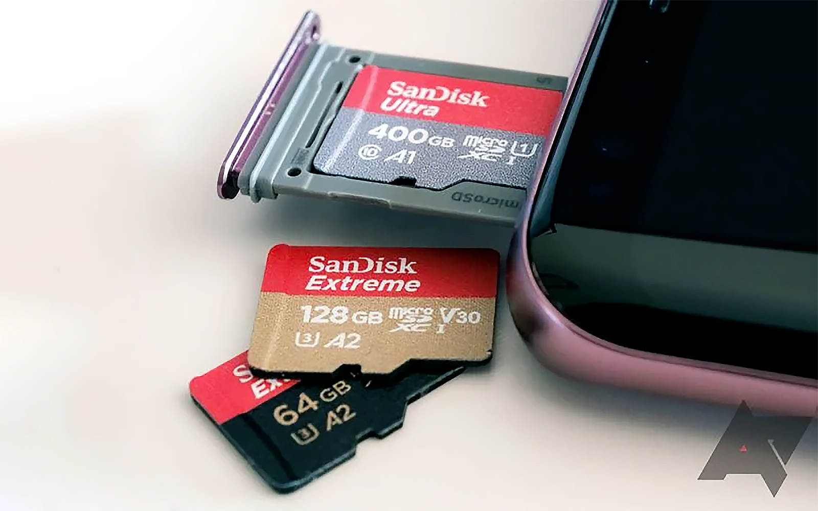 three sd cards resting next to an Android device
