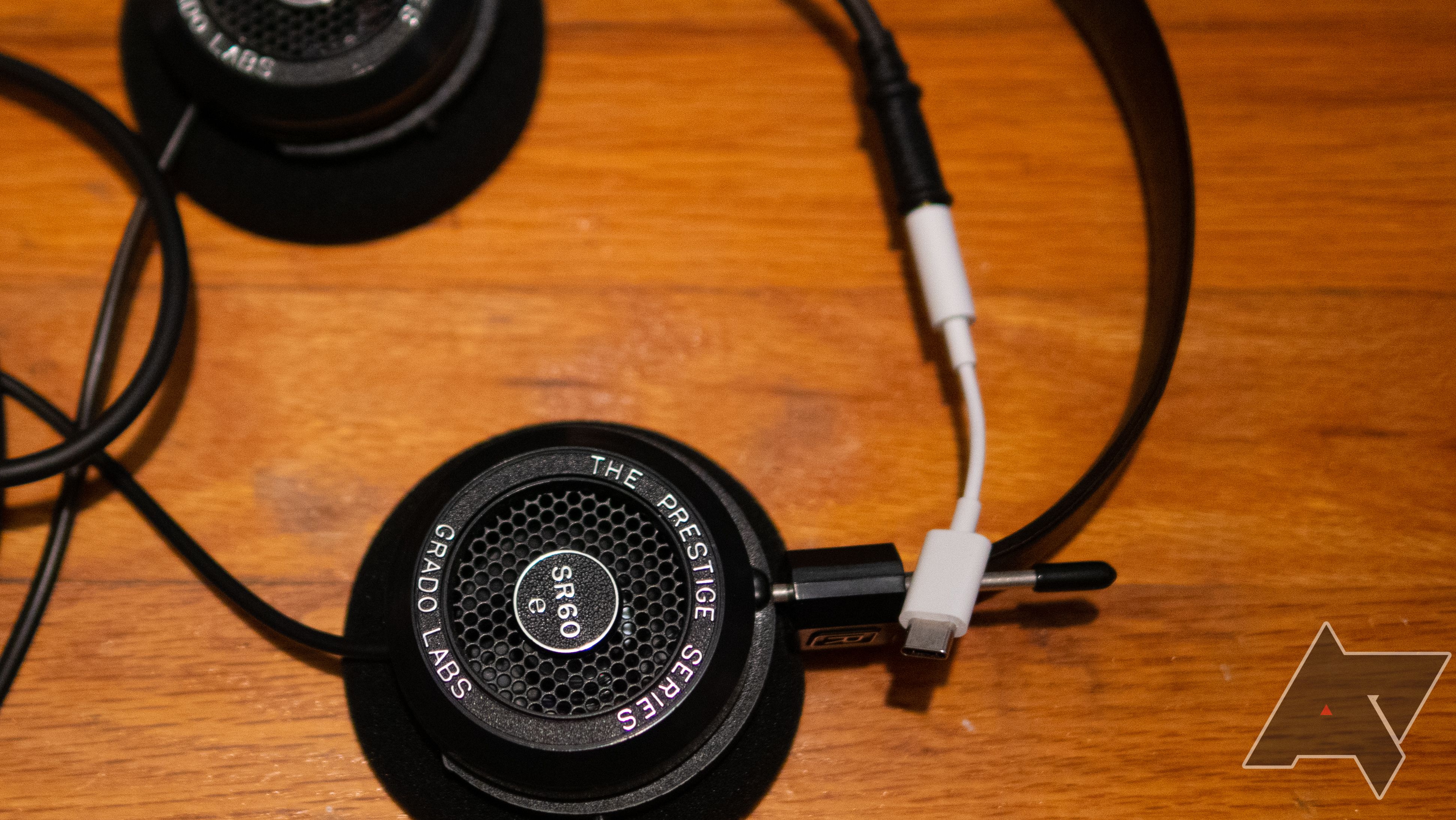 An image of Grado headphones with a USB-C dongle DAC on a wooden desk