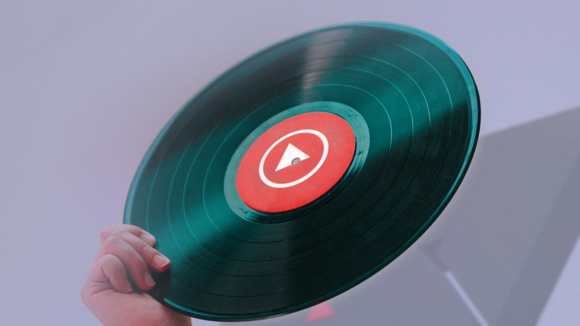 The YouTube Music logo in the center of a vinyl album