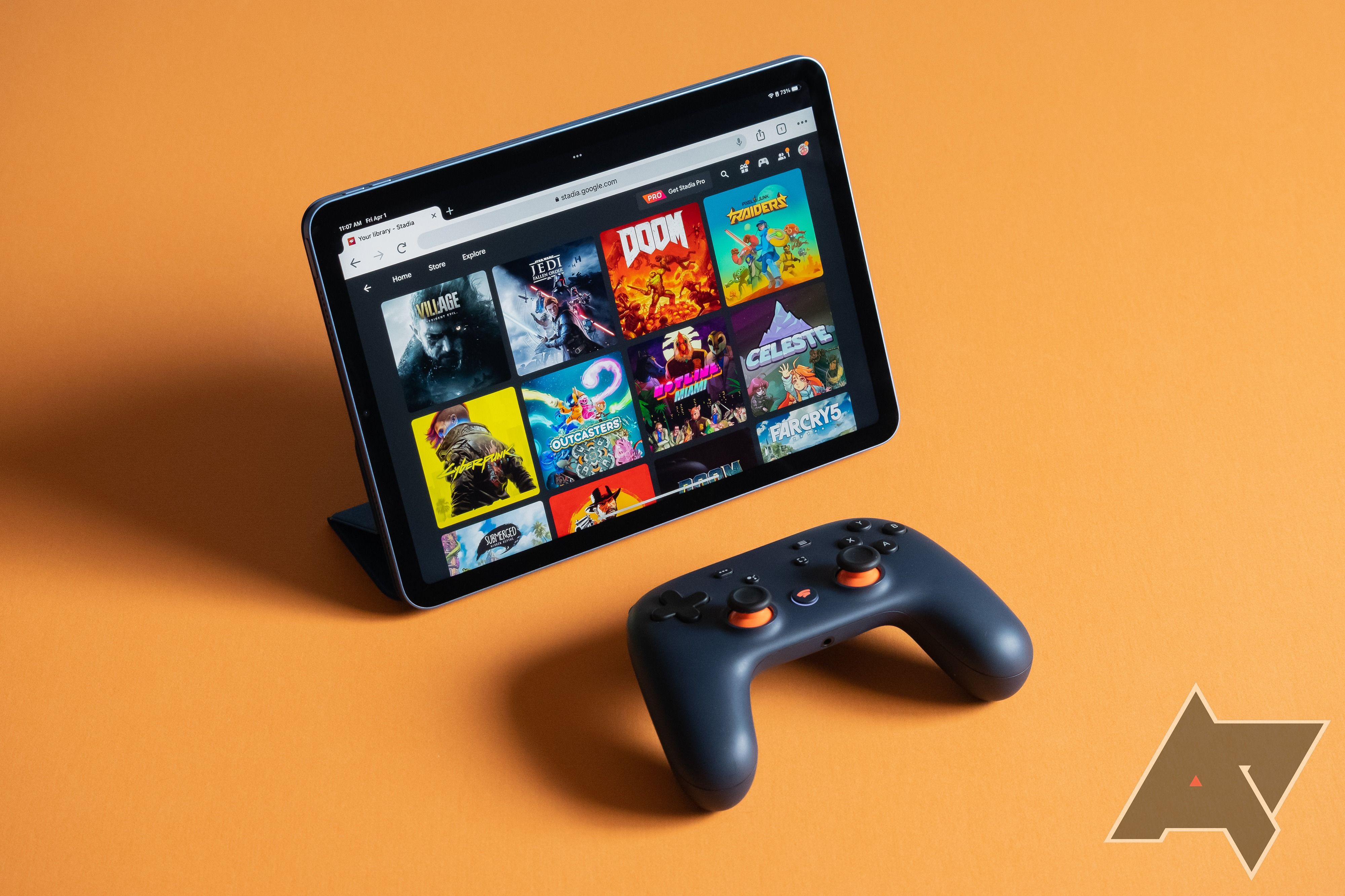 Google Stadia on an iPad Air with a Stadia controller in front of it on an orange background