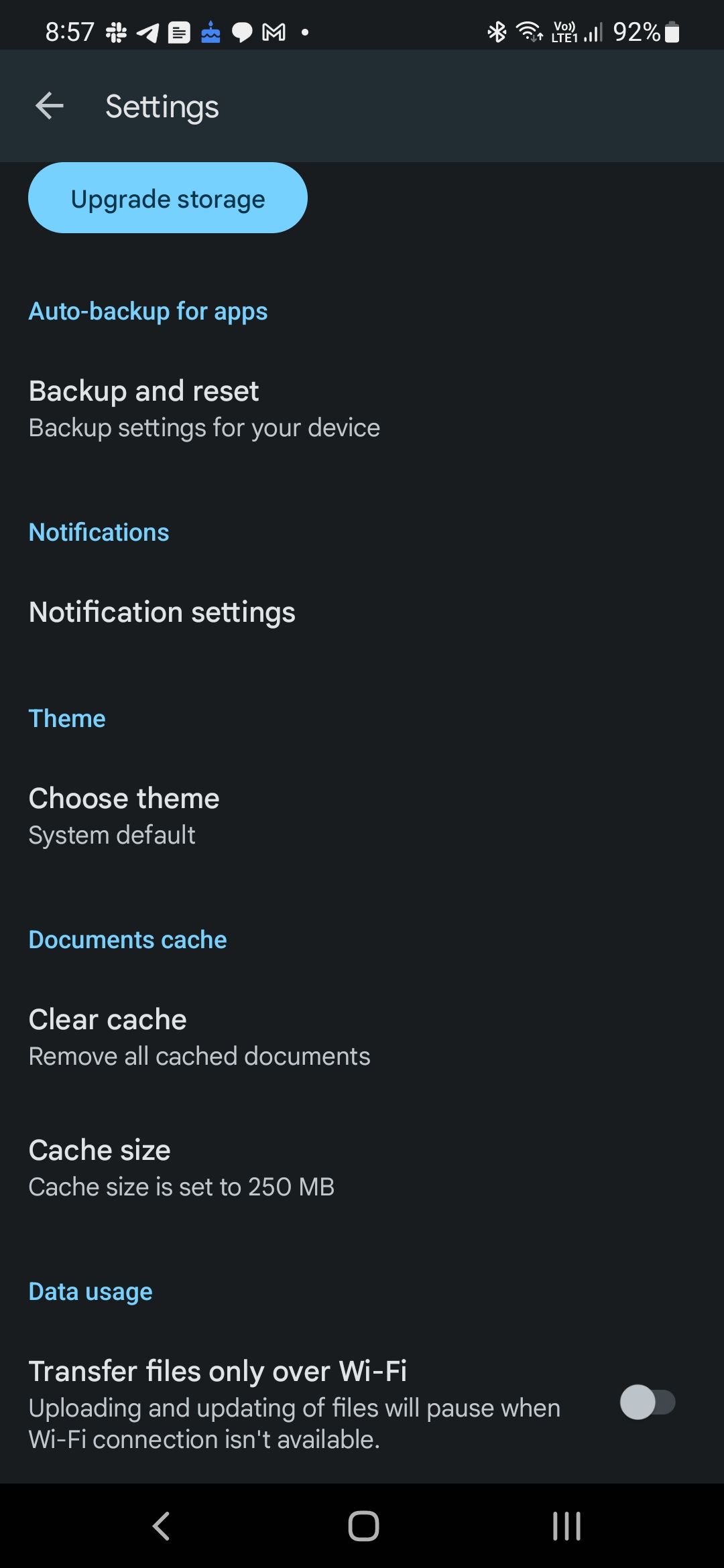 A screenshot of Google Drive settings on a mobile device, featuring options such as 'Upgrade storage', 'Auto-backup for apps', 'Backup and reset', and 'Notification settings'. 'Theme' is set to 'System default', and 'Documents cache' includes a 'Clear cache' function. 'Data usage' shows a disabled toggle for 'Transfer files only over Wi-Fi'.