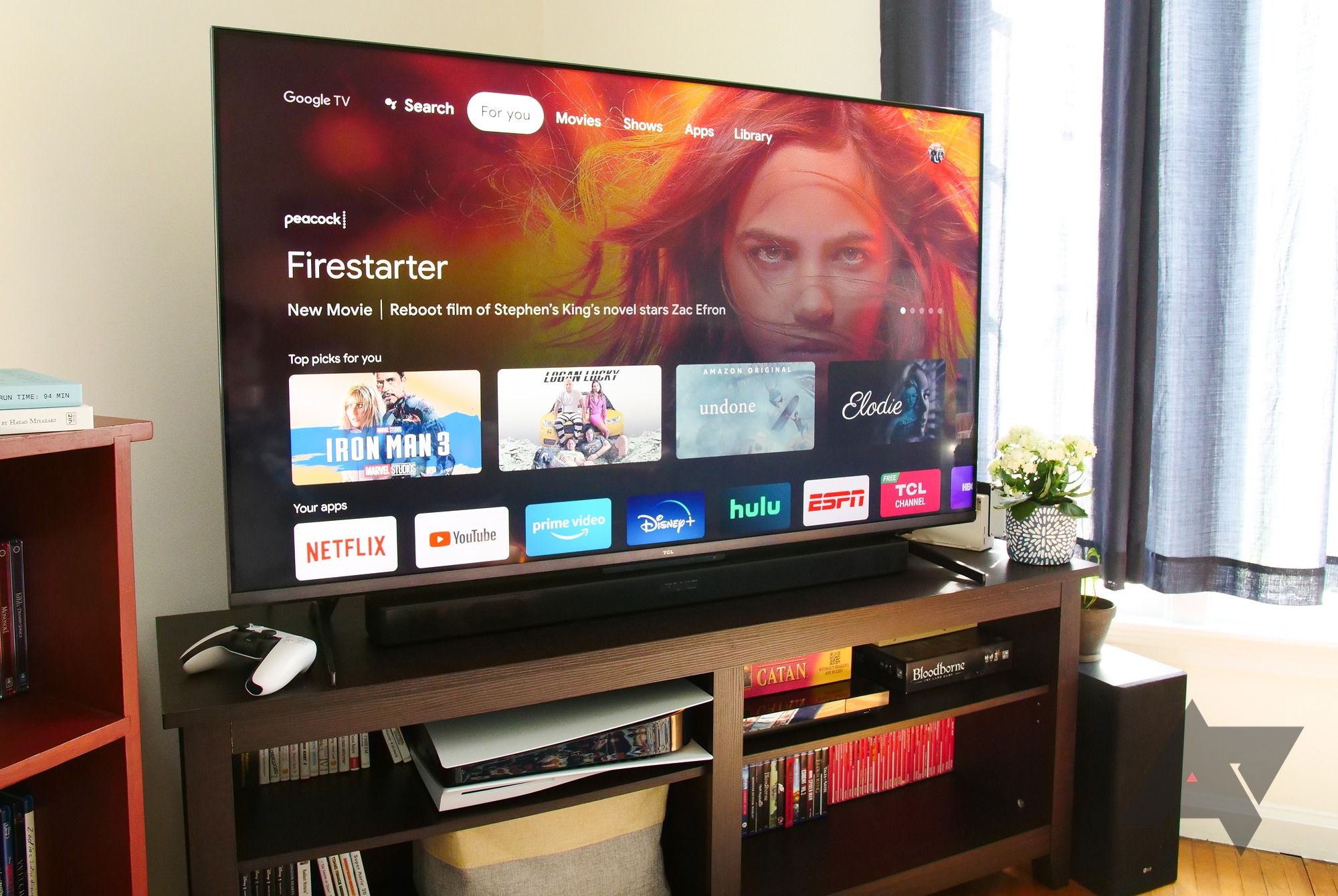 A TCL 6 series TV sitting on an entertainment center