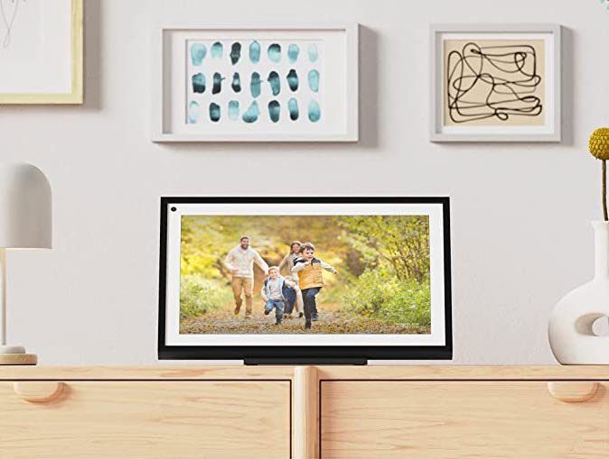 An Echo Show 16 sits atop a chest with artwork above it. 