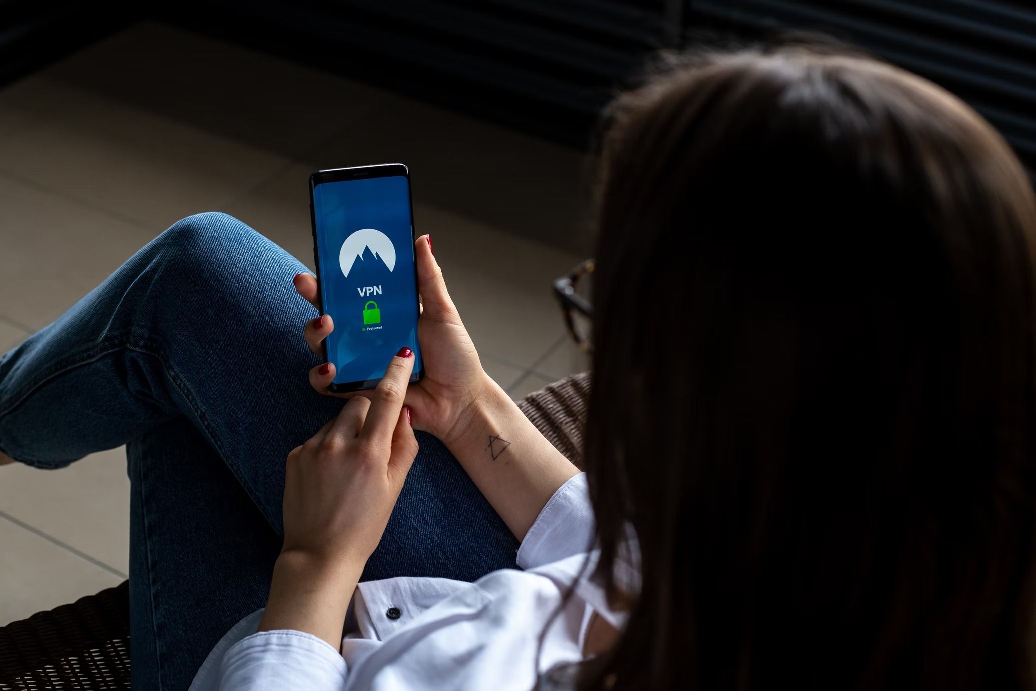 woman holding phone with vpn logo