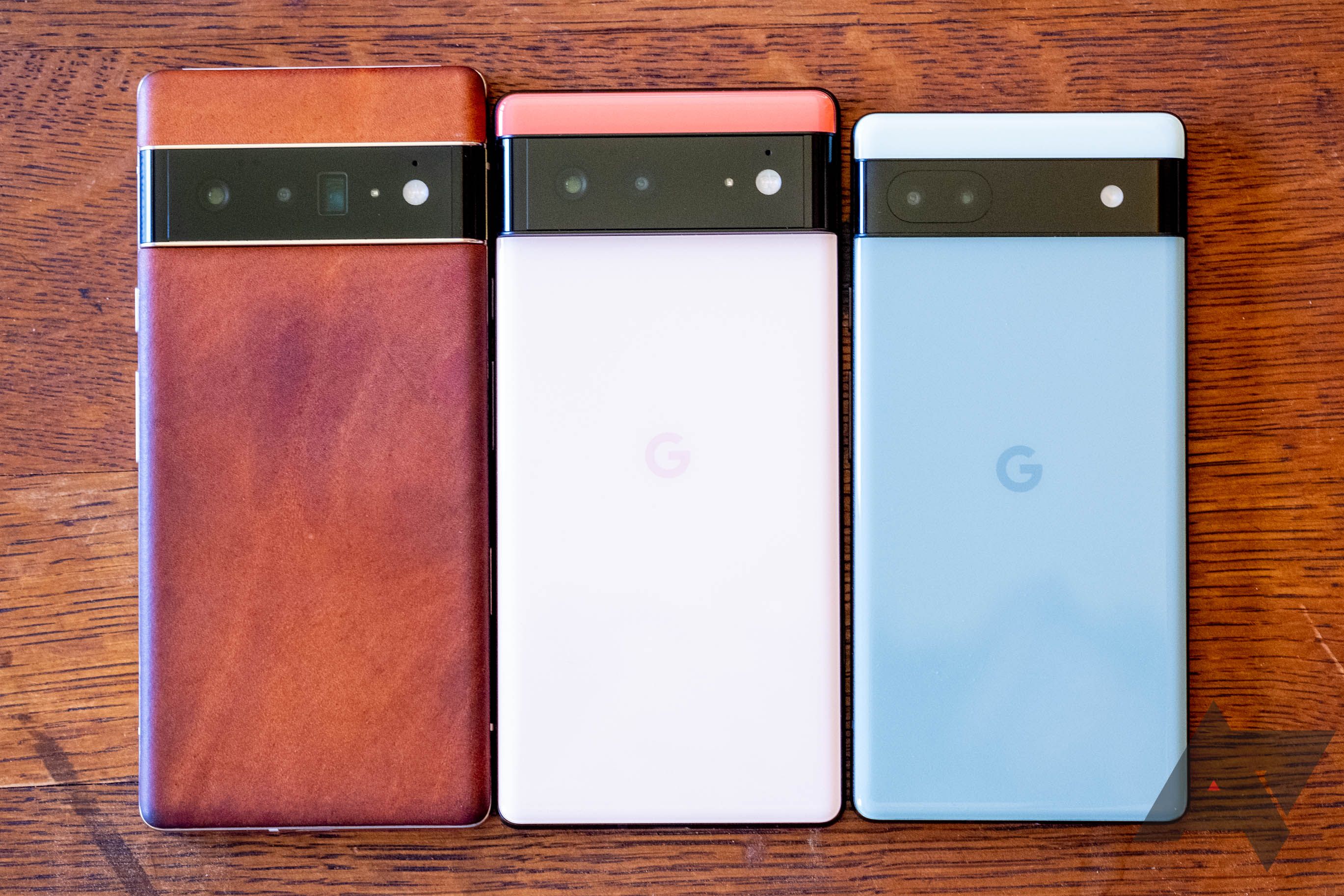 The Pixel 6 Pro, Pixel 6, and Pixel 6a facebdown on a wooden table
