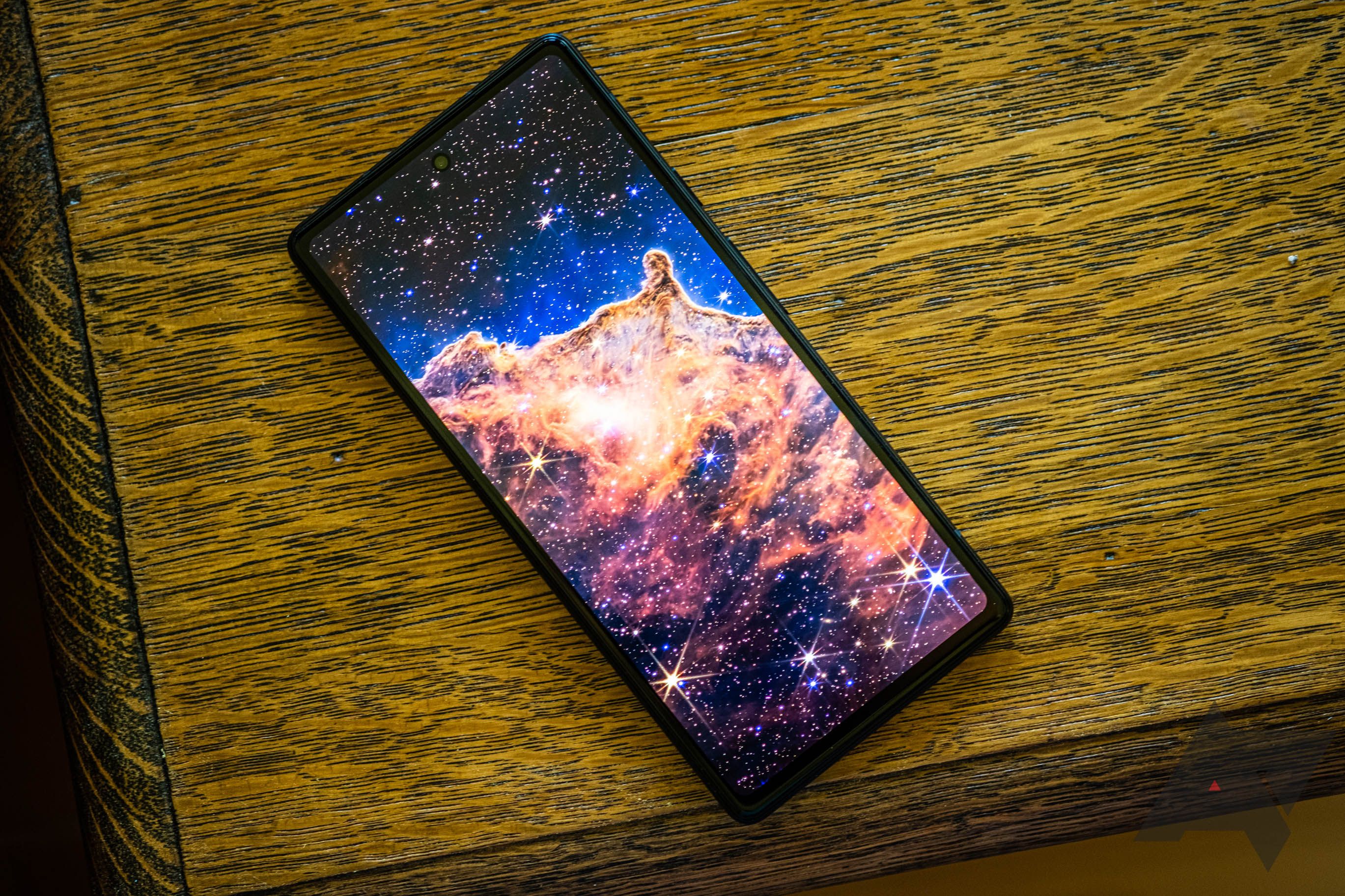 The Google Pixel 6a sitting on a wooden surface