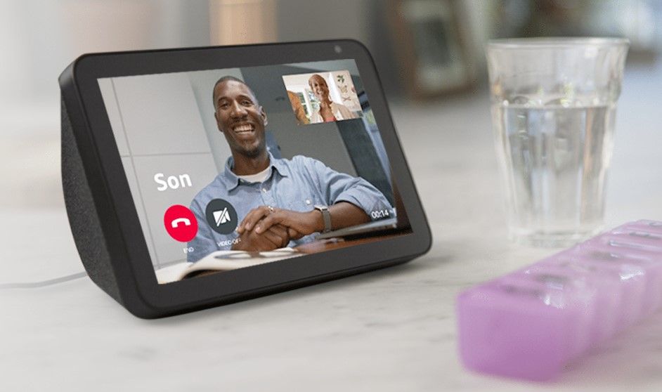 An Echo show sits on a table and displays an incoming call from the owners son