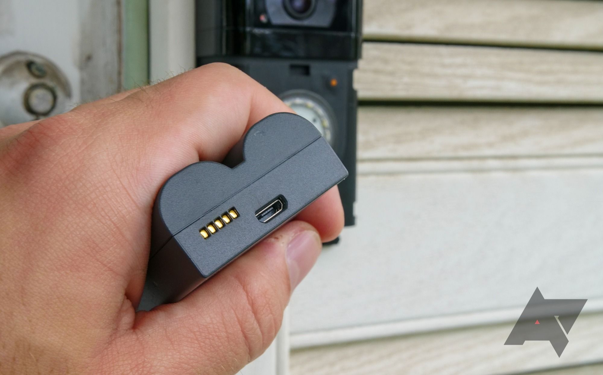 A hand holding the Ring Video Doorbell 4 battery