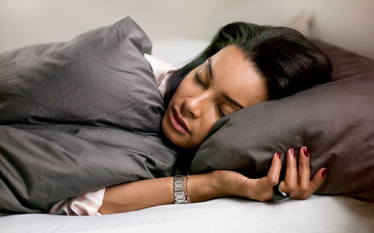 Woman sleeping while Oura Ring tracks her sleep quality.