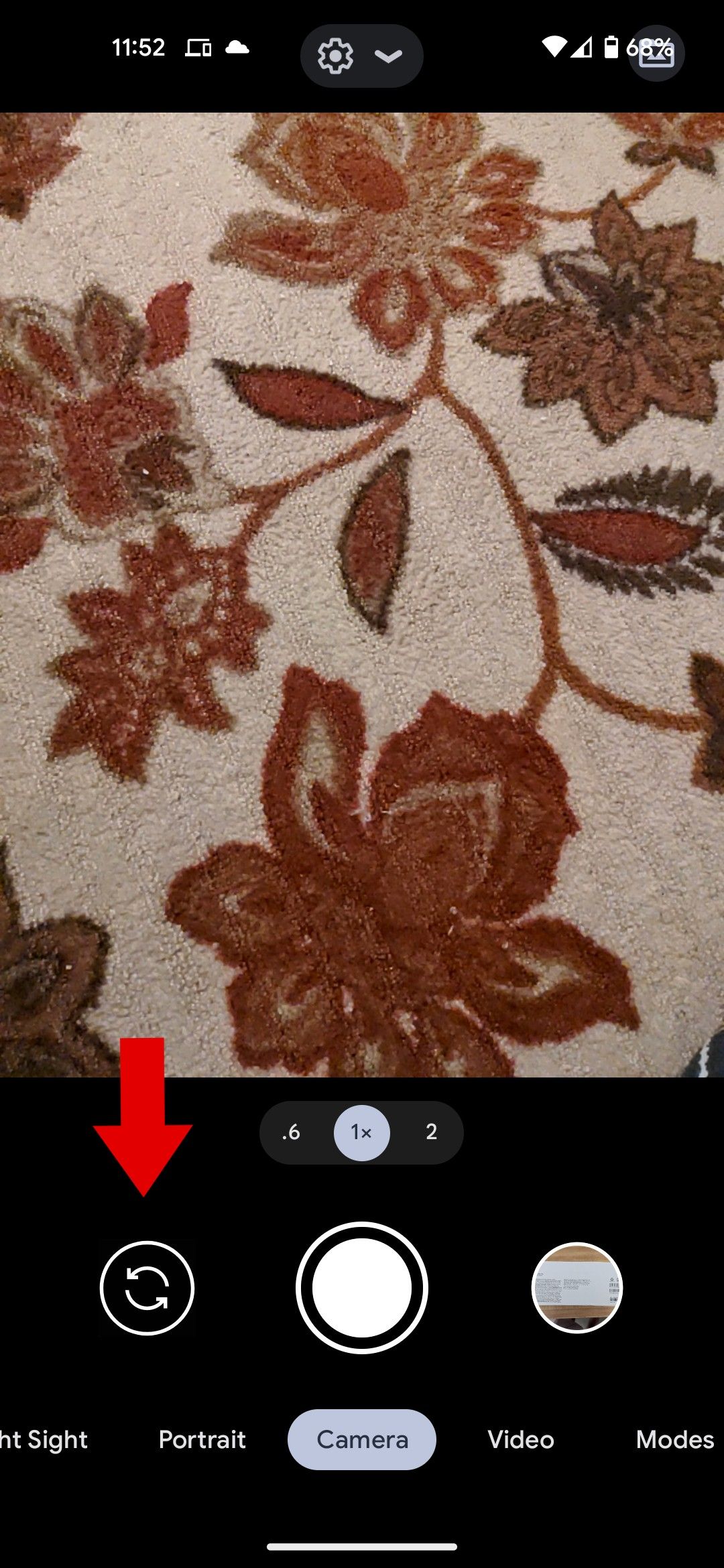 The Google camera app with a red arrow pointing to the camera toggle.