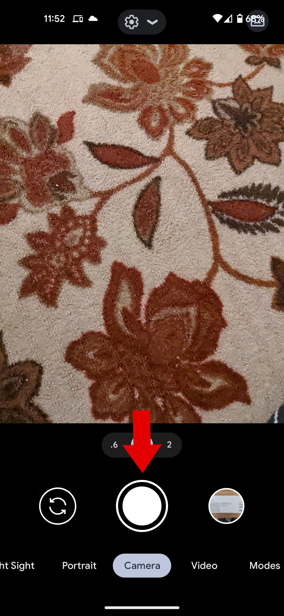 The Google camera app with a red arrow pointing to the shutter button.