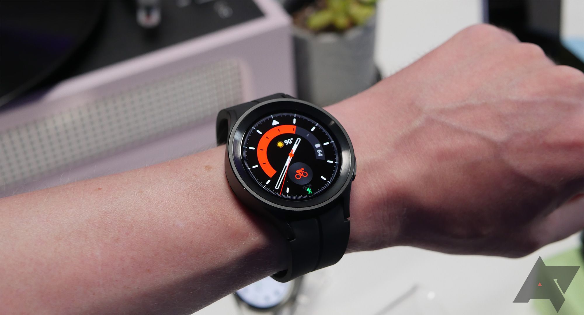 A person wearing smartwatch with an illuminated display; the watch is in focus. 