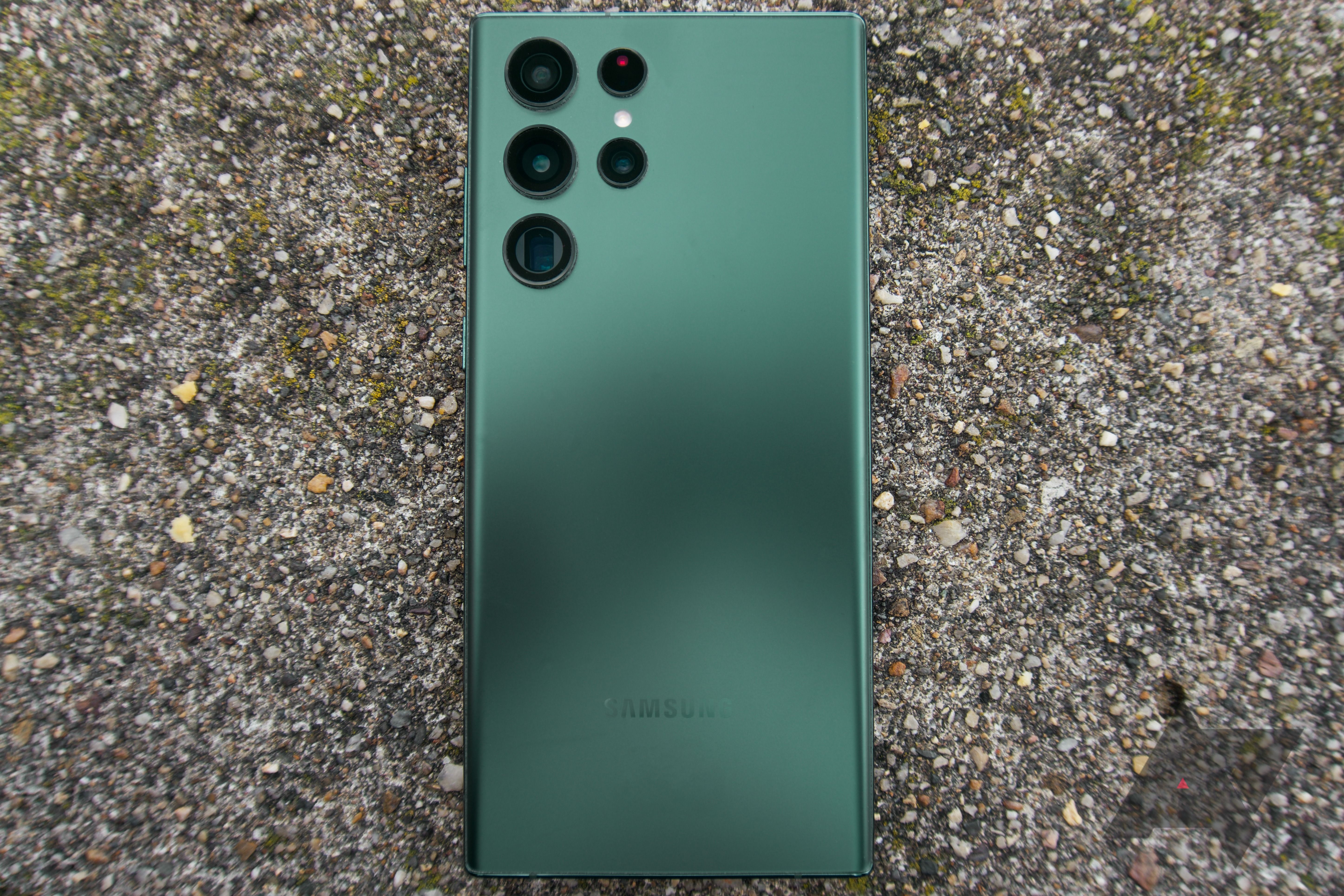 A green Galaxy S22 Ultra face down on concrete