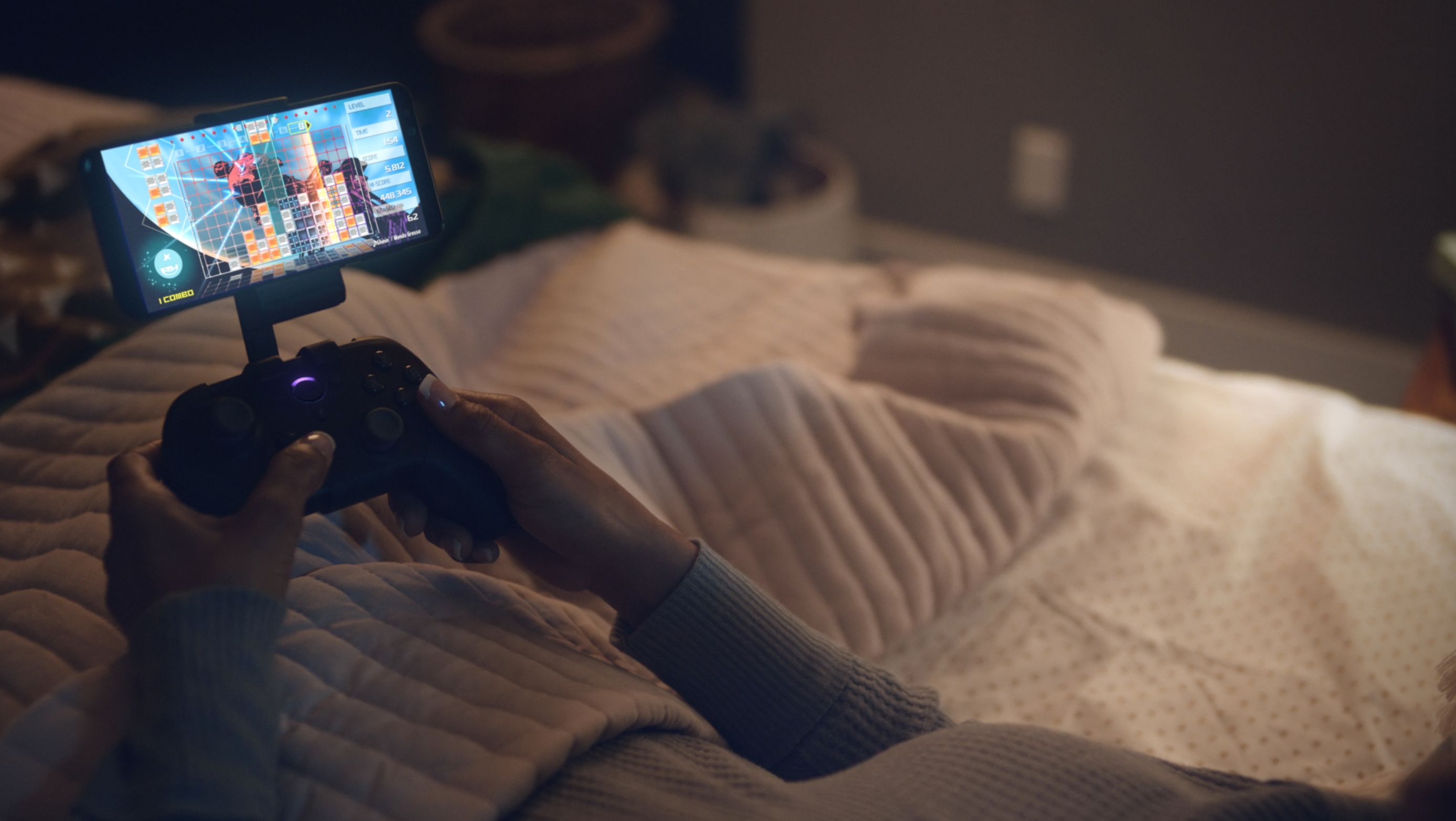 using luna controller connected to a phone on a stand while laying in bed 