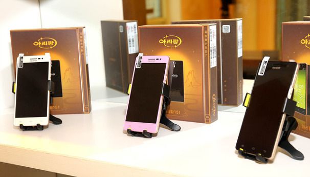 three smartphones with screens off on stands