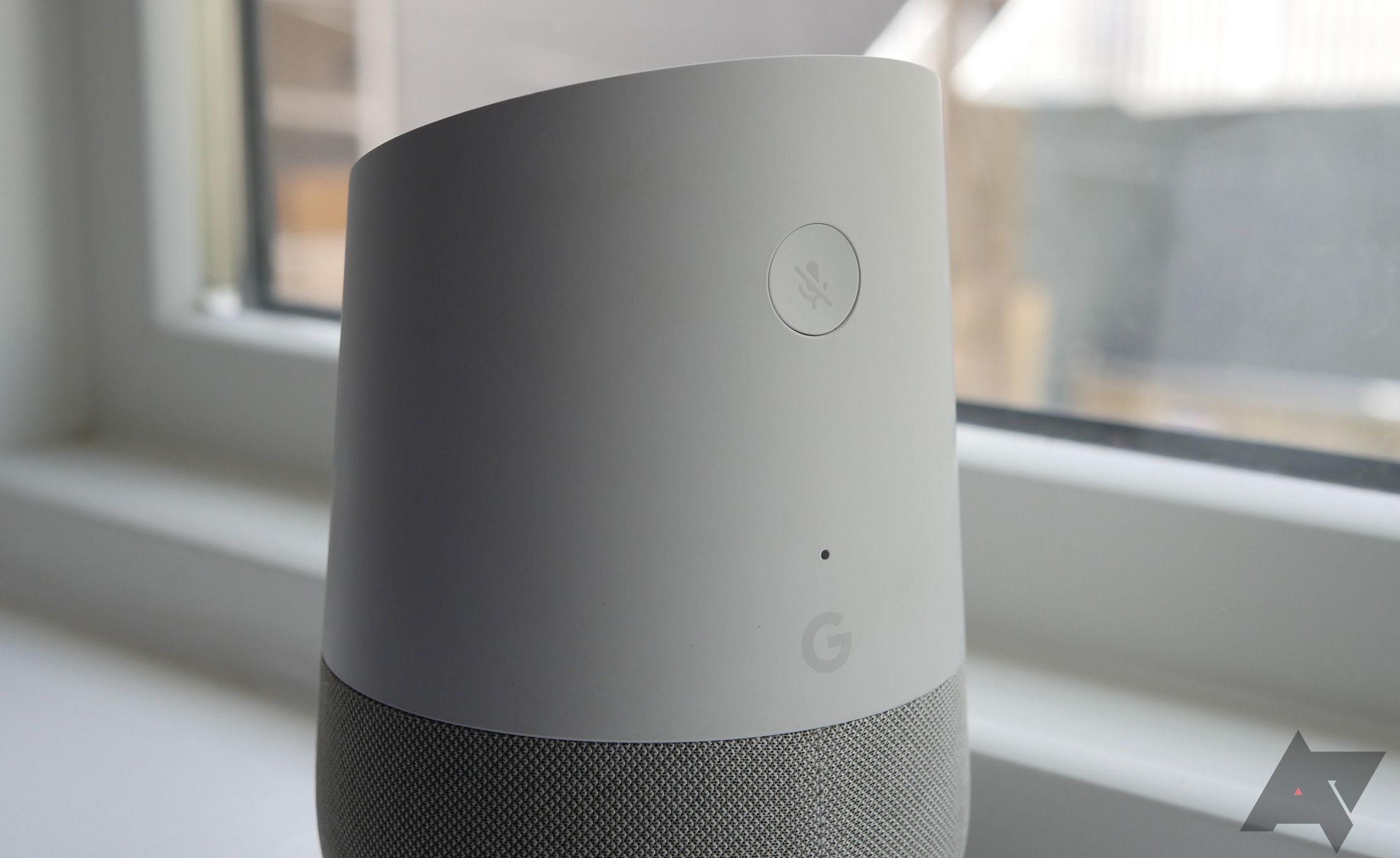 The back of a first generation Google Home speaker showing the microphone off button