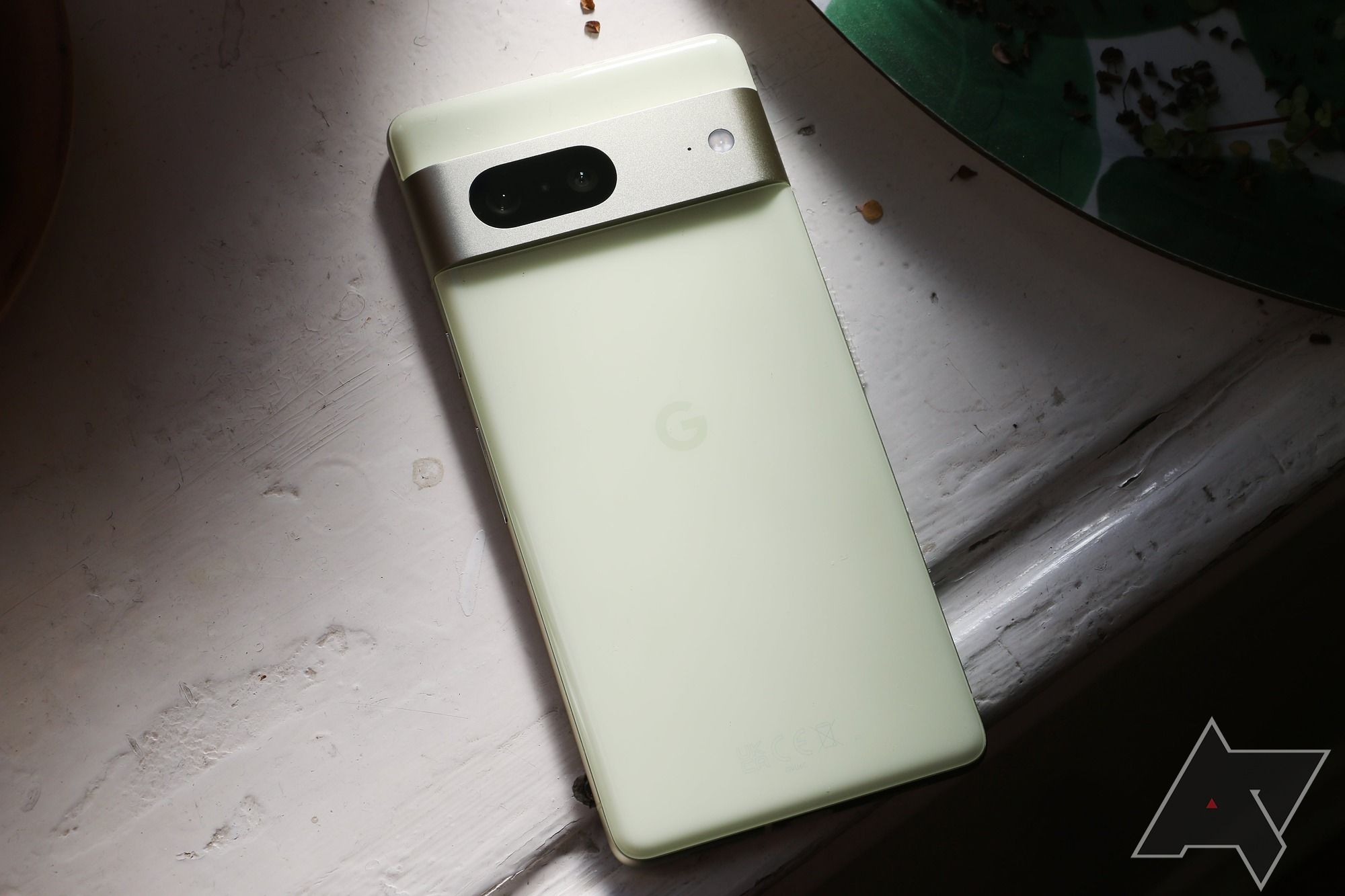 Google Pixel 7 laying face down with back visible and a beam of light shining on it.