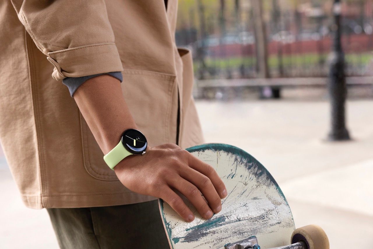 A person wearing a Google Pixel Watch and getting ready to ride a skateboard