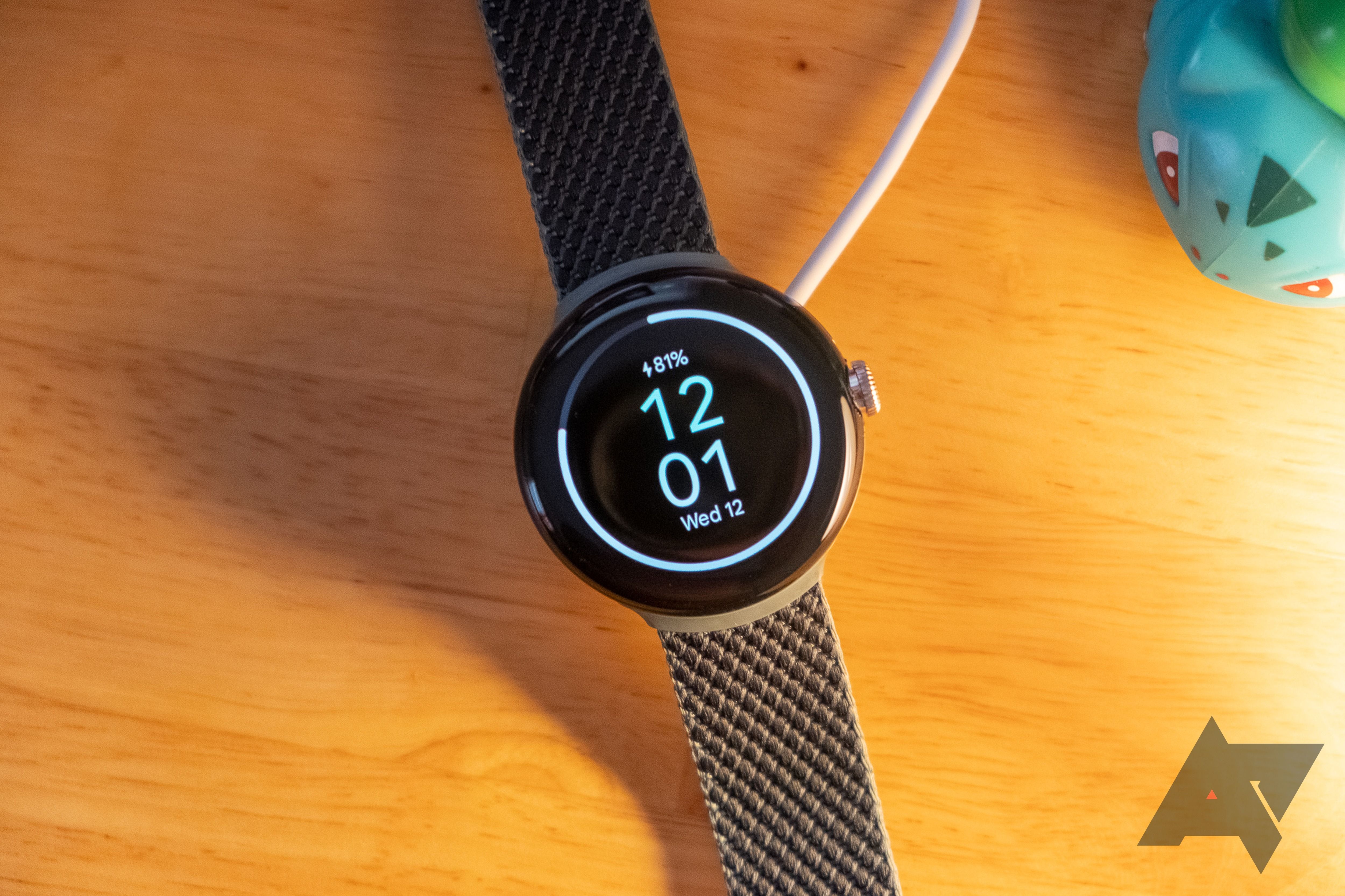 A smartwatch charging on a desk.