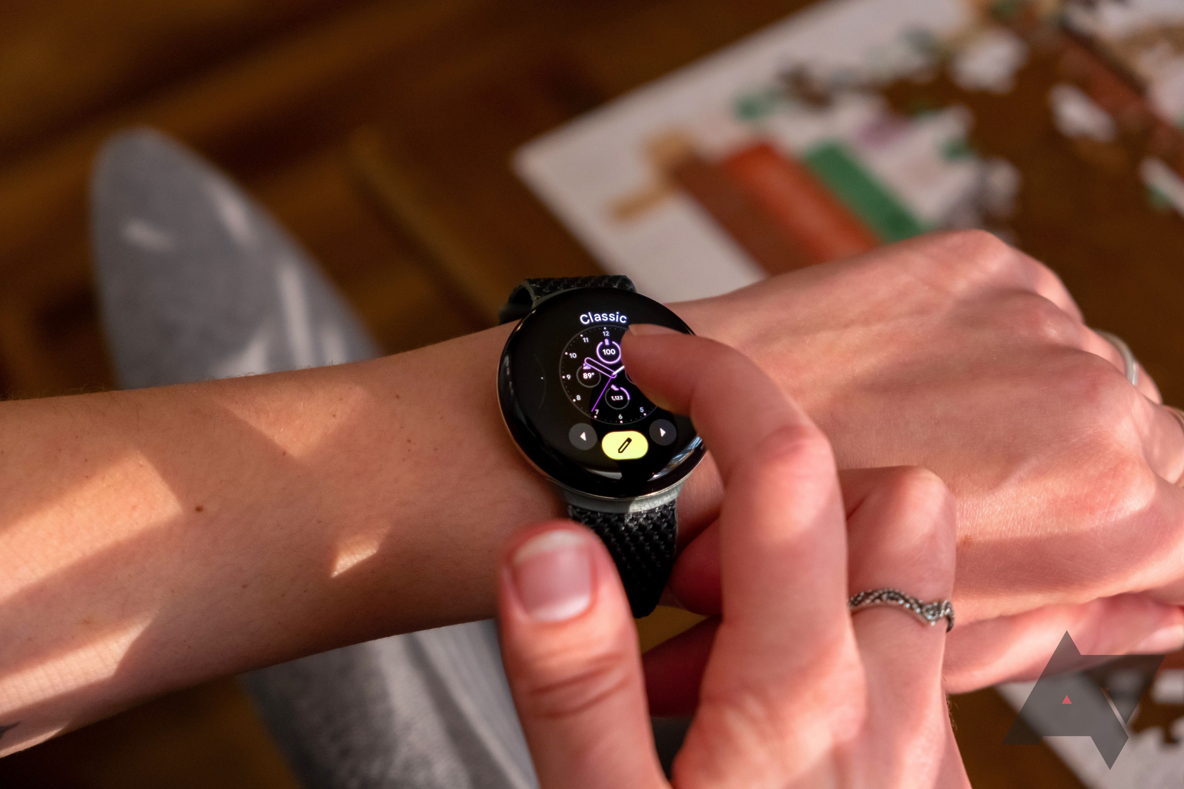 A person changing the watch face on a smartwatch.