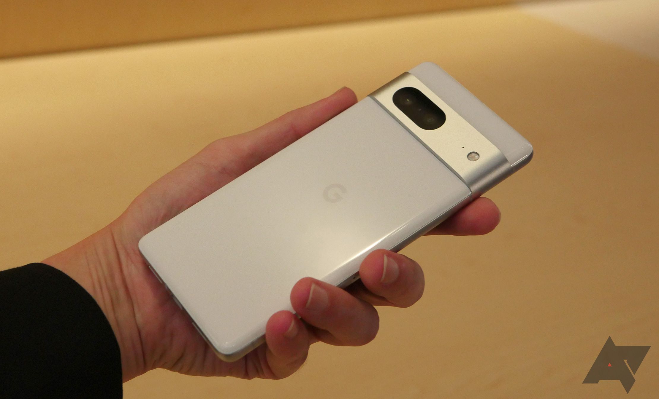 White colored Google Pixel 7 being held in left hand