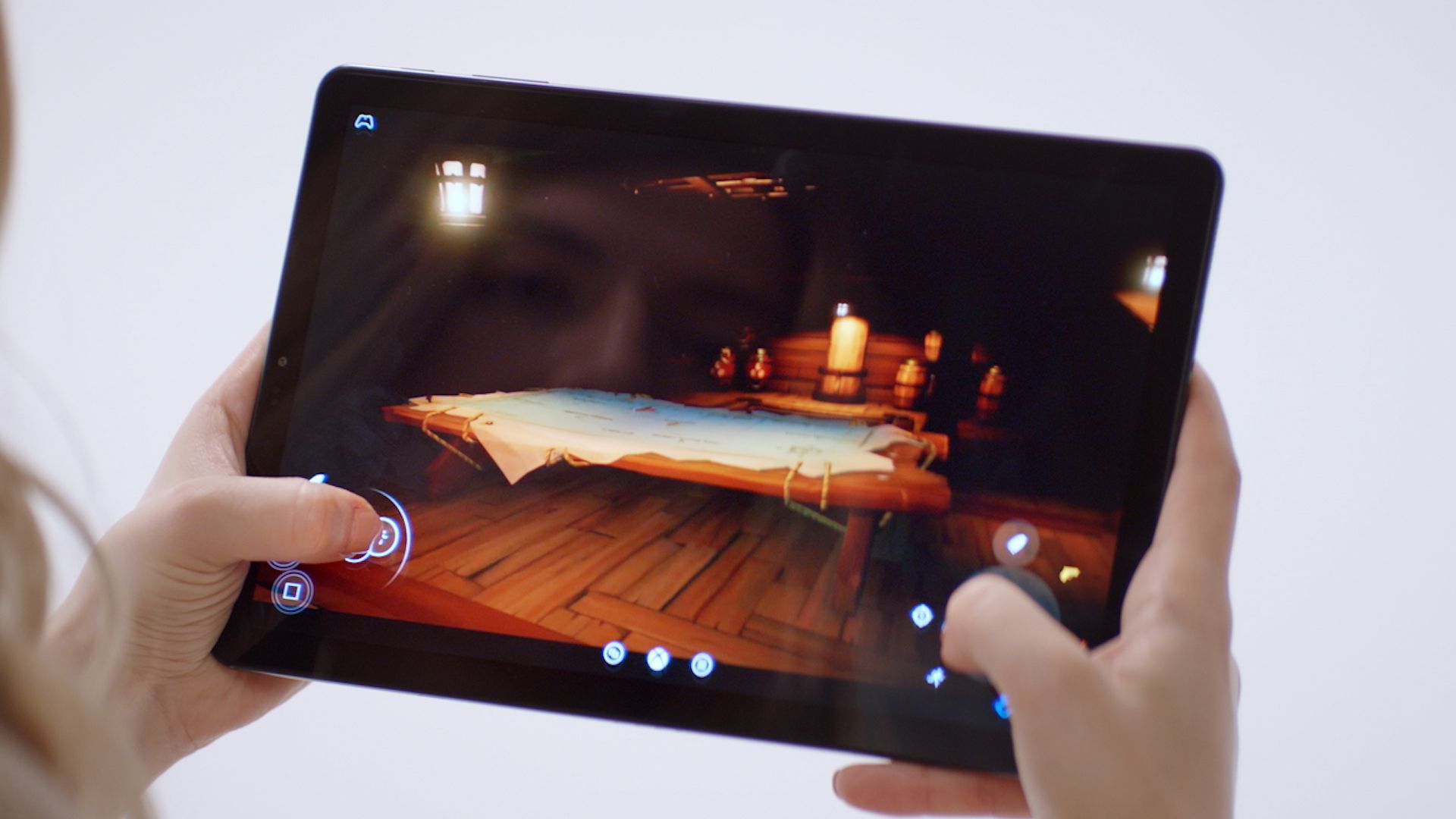 holding a tablet with thumbs on the game controls