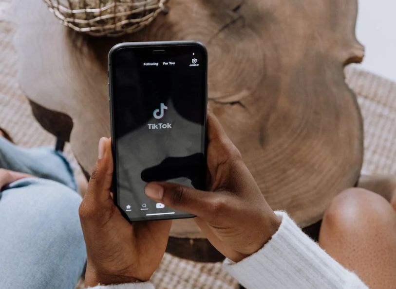 Person opening TikTok app on smartphone.