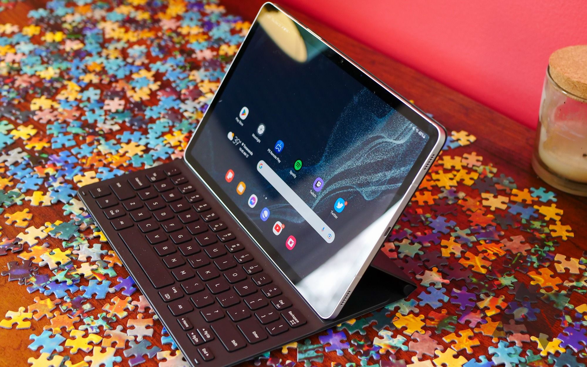 A Galaxy Tab S8 tablet slotted into a keyboard dock laid on puzzle pieces.