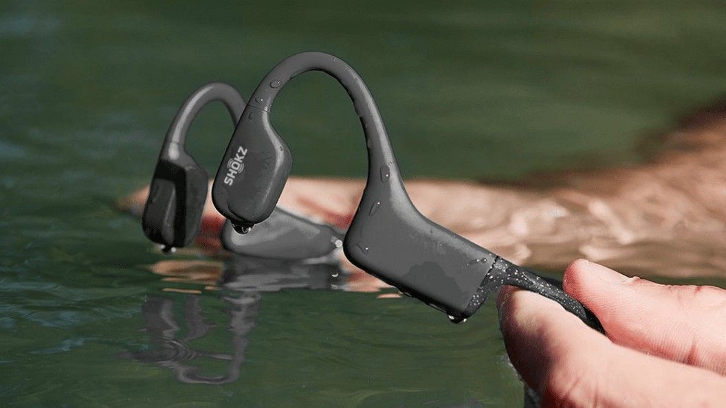 Holding Shokz Bone Conduction Headphones in water