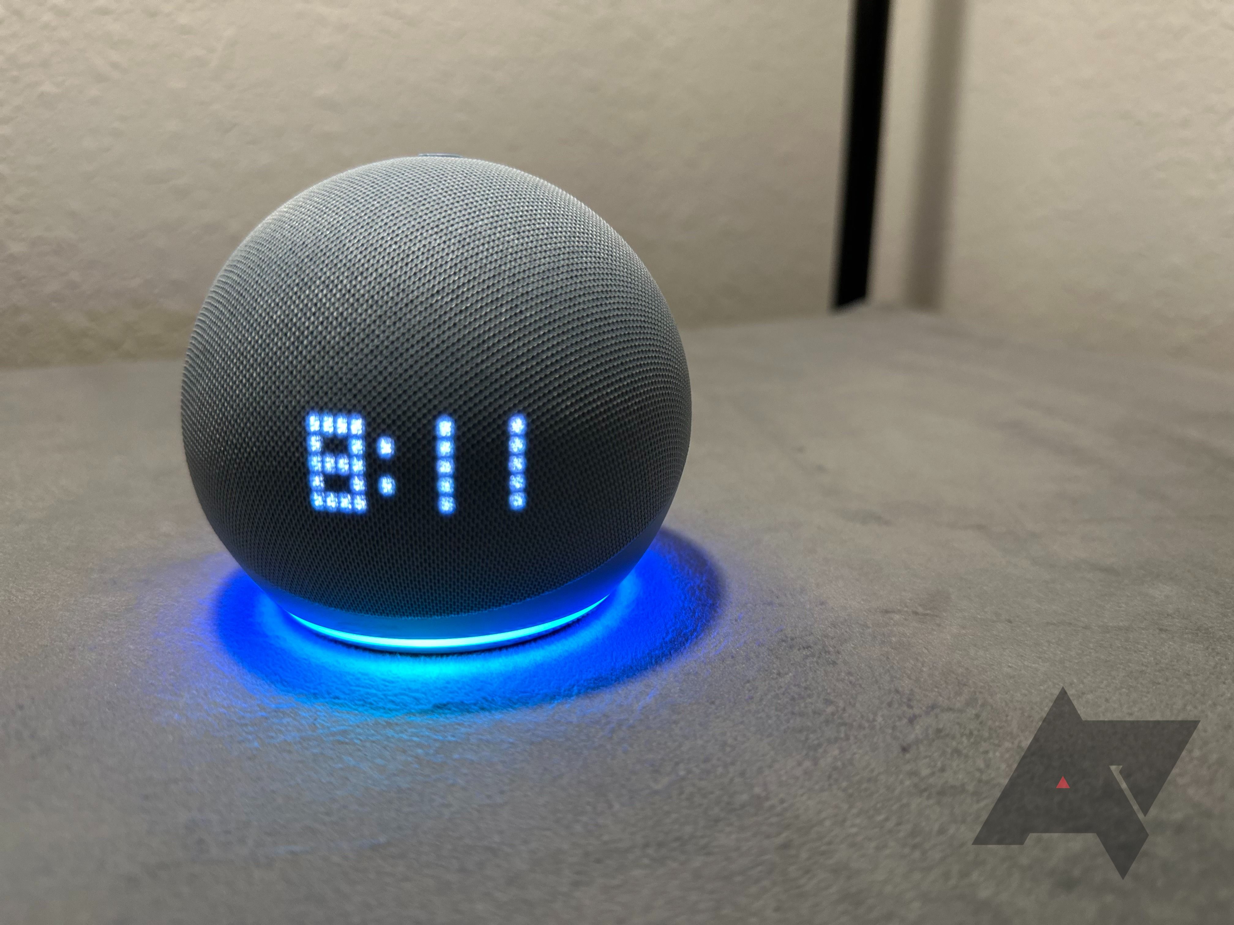 Sebuah Amazon Echo Dot dengan Jam dengan cahaya biru bercahaya yang menunjukkan waktu