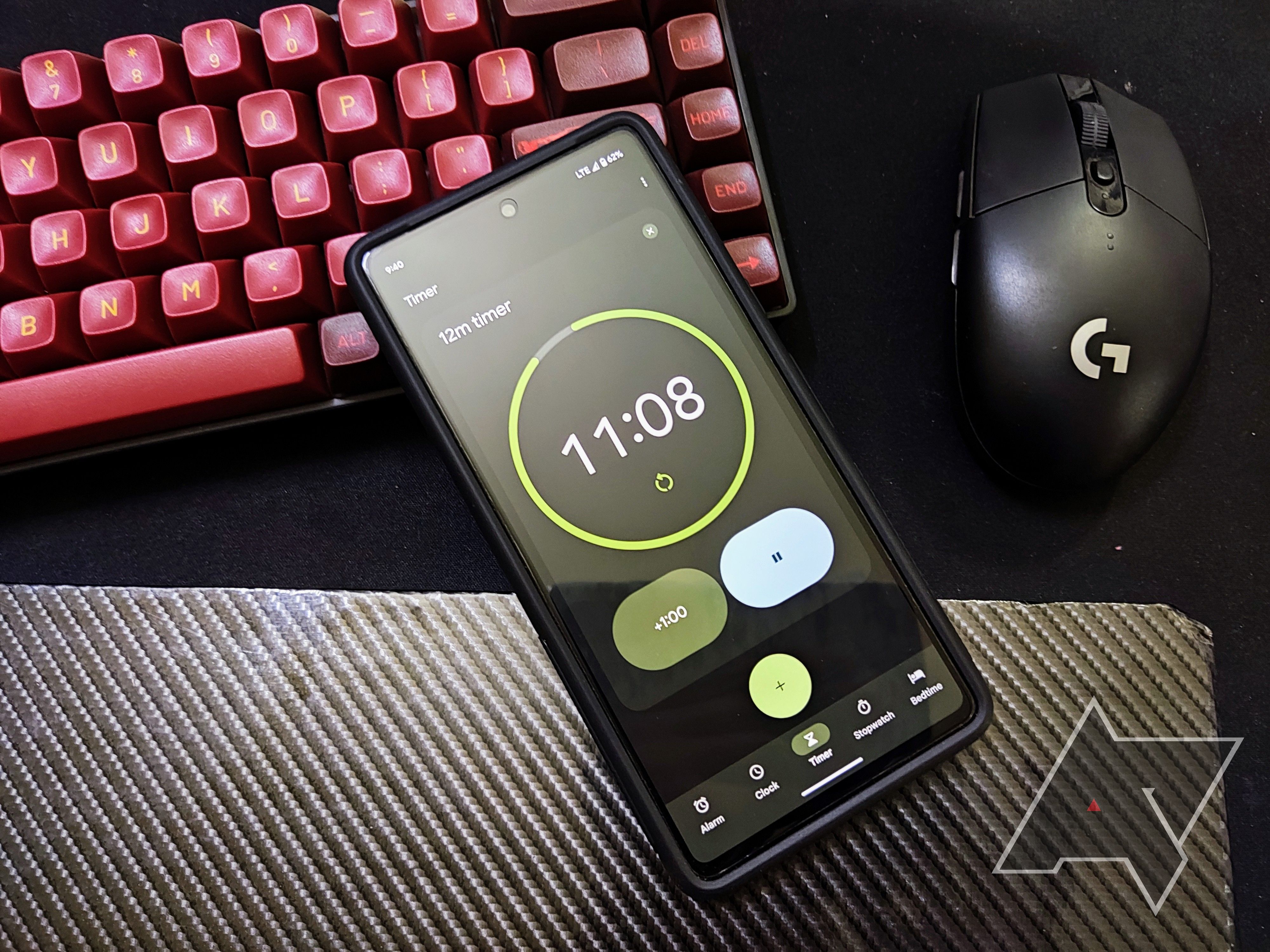 The Google Clock app displayed on a phone screen with a keyboard and mouse in the background