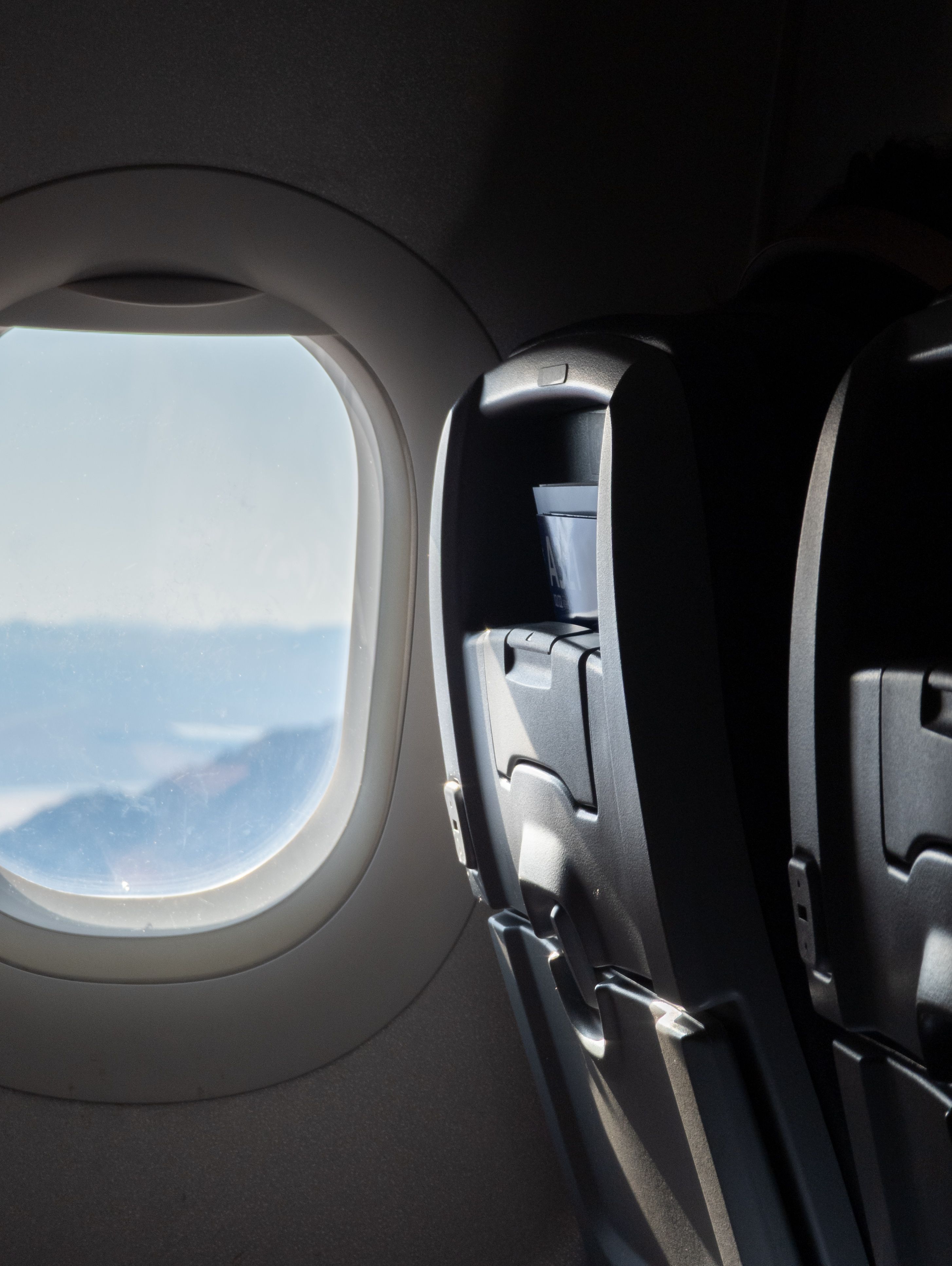 File foto RAW yang memperlihatkan jendela dan kursi pesawat, diedit untuk mengubah Sorotannya.