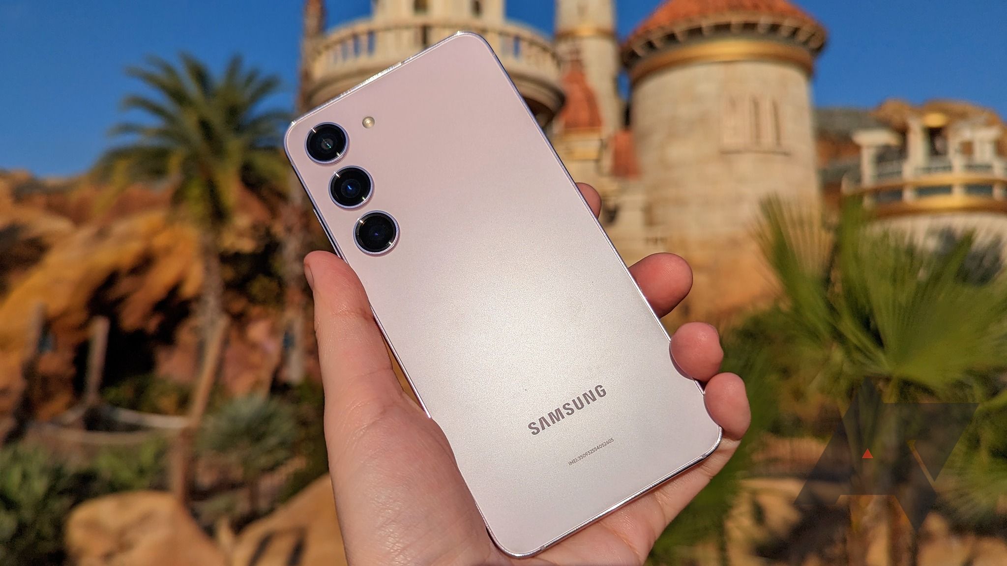 Samsung Galaxy S23 held in a hand with a castle in the background