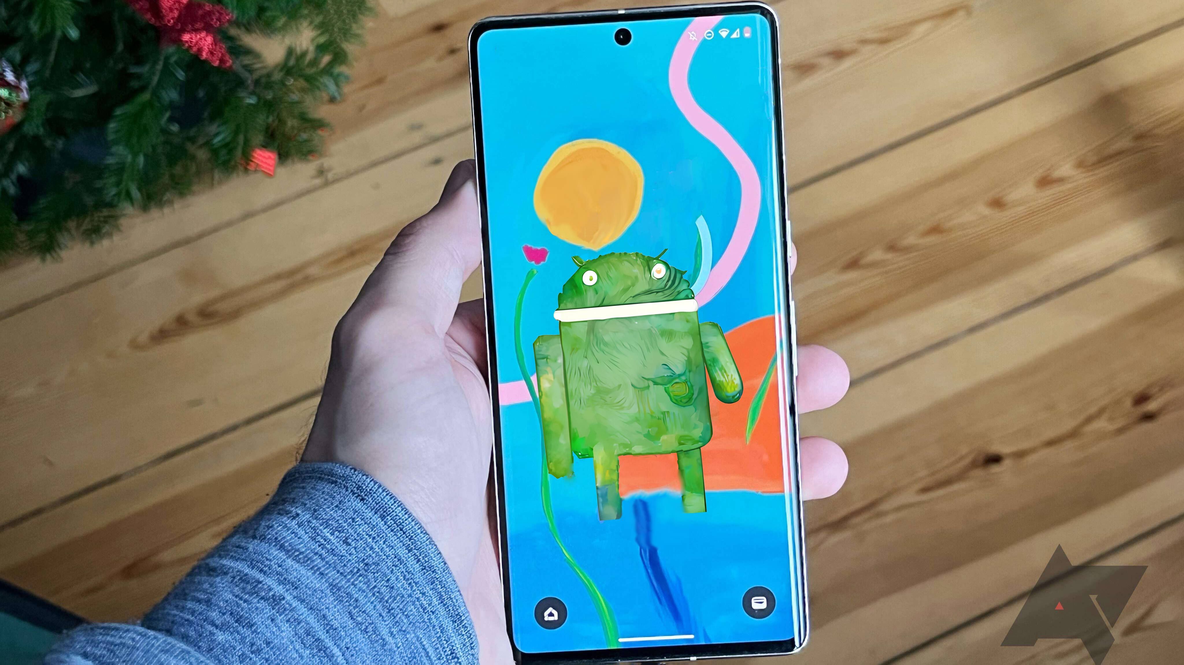A person holds a Pixel 7 Pro phone with an impressionist wallpaper