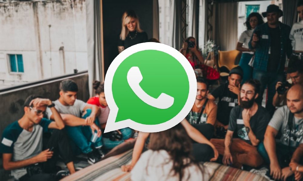 The WhatsApp logo on top of a photo of a group of people