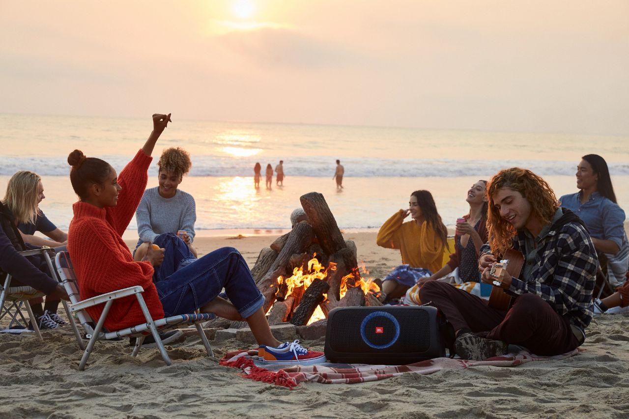 People on the beach using the JBL PartyBox on-the-go 