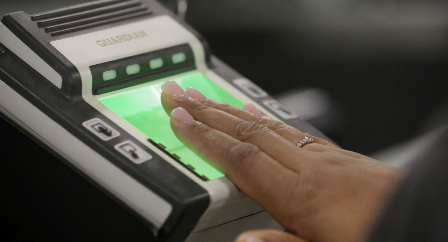 hand pressed to a fingerprint scanner