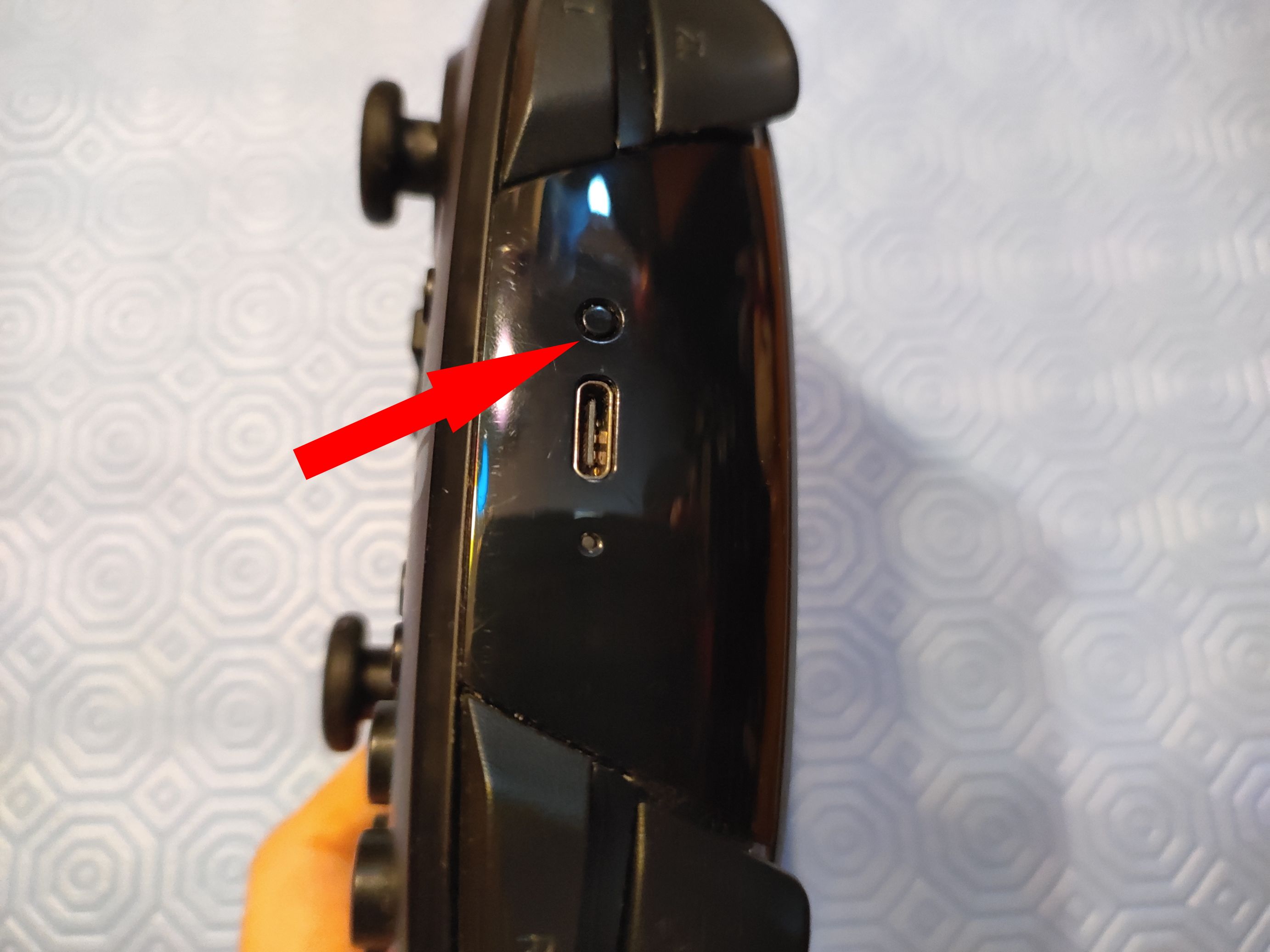 Fotografia do botão de sincronização de um controle do Nintendo Switch Pro